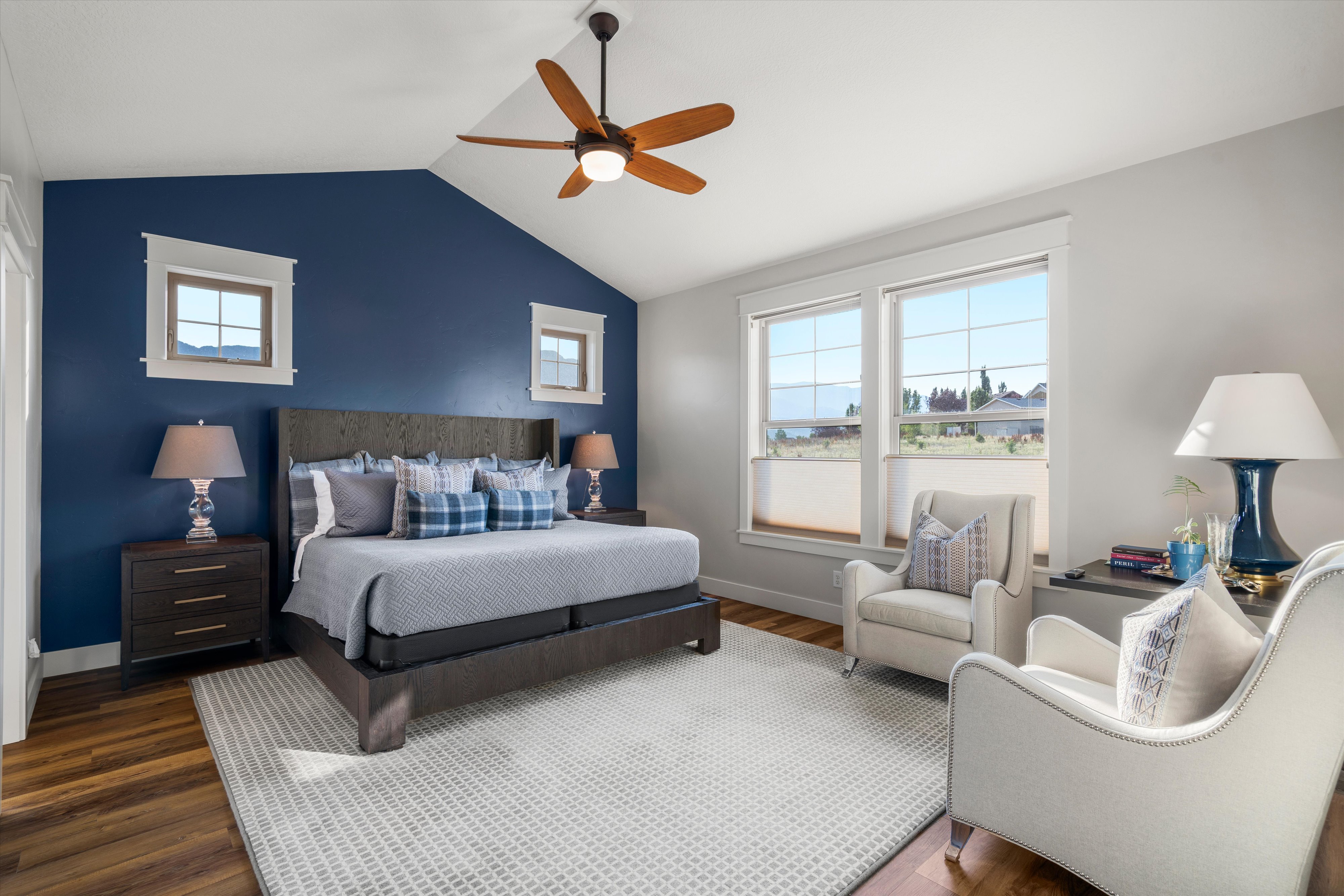 Spacious room with a vaulted ceiling featuring a wood-finish ceiling fan