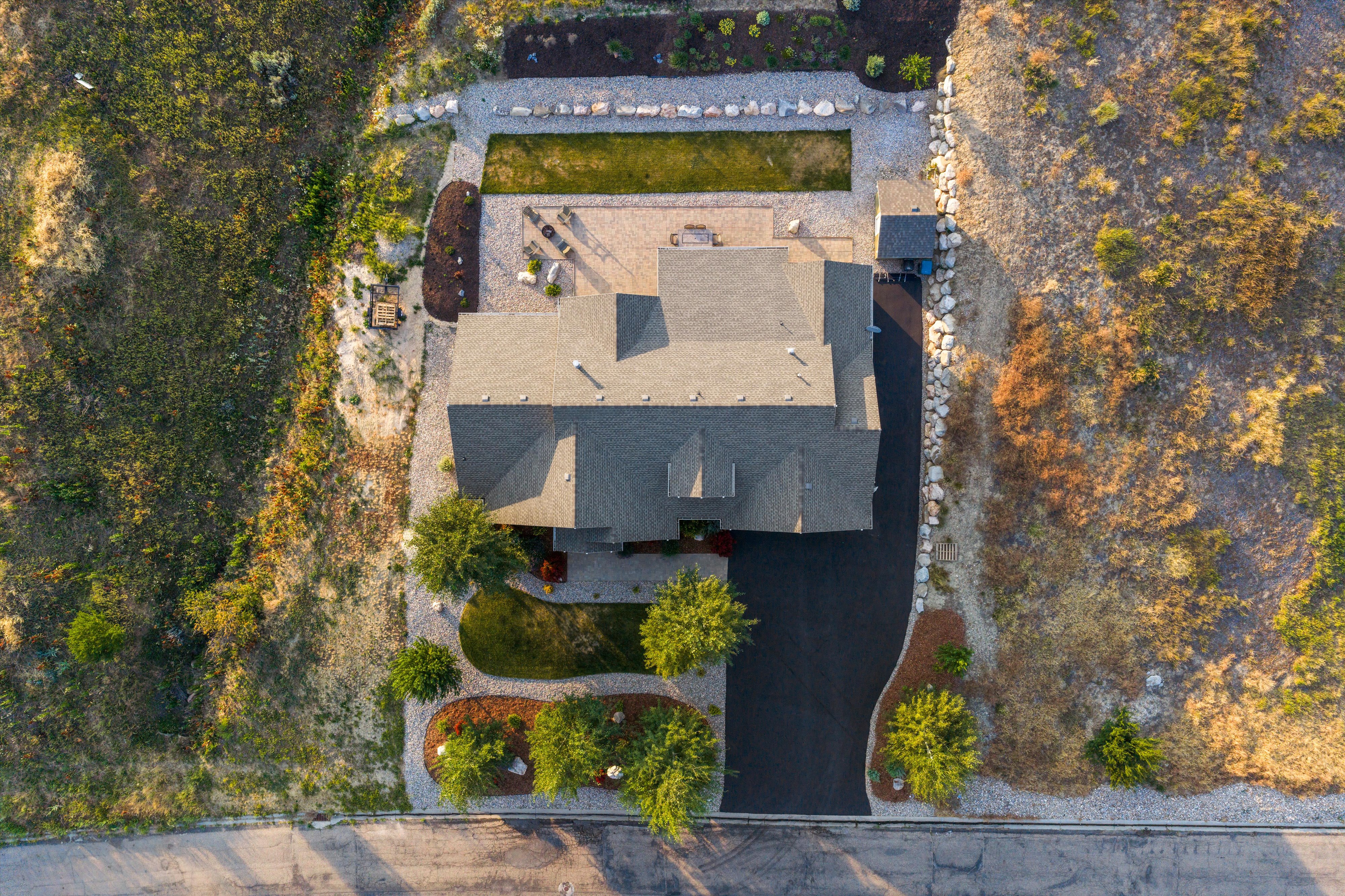 Single-family residence featuring a dark asphalt driveway and a multi-gabled roofline
