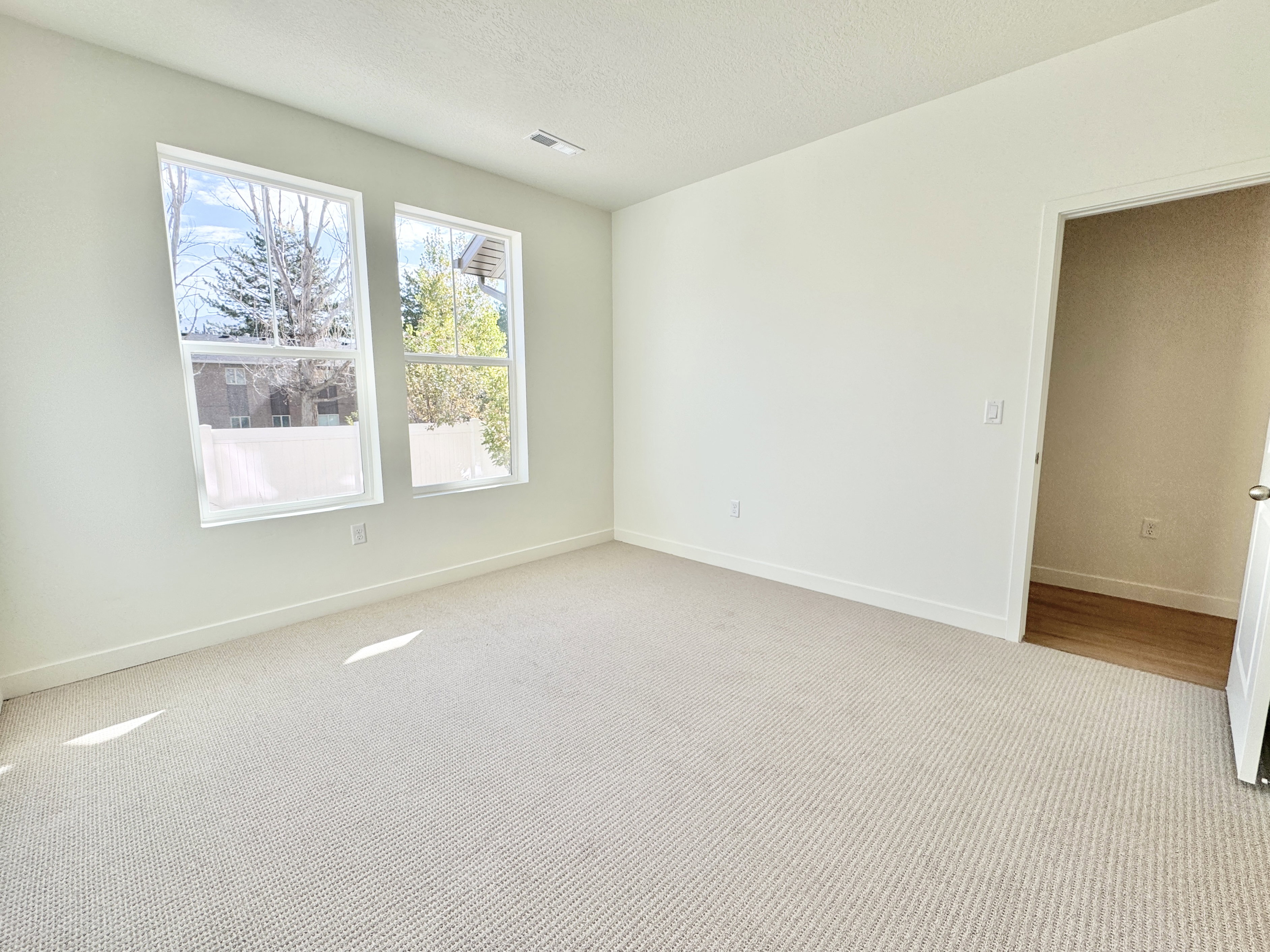 Light-filled interior space with two large windows and neutral wall tones
