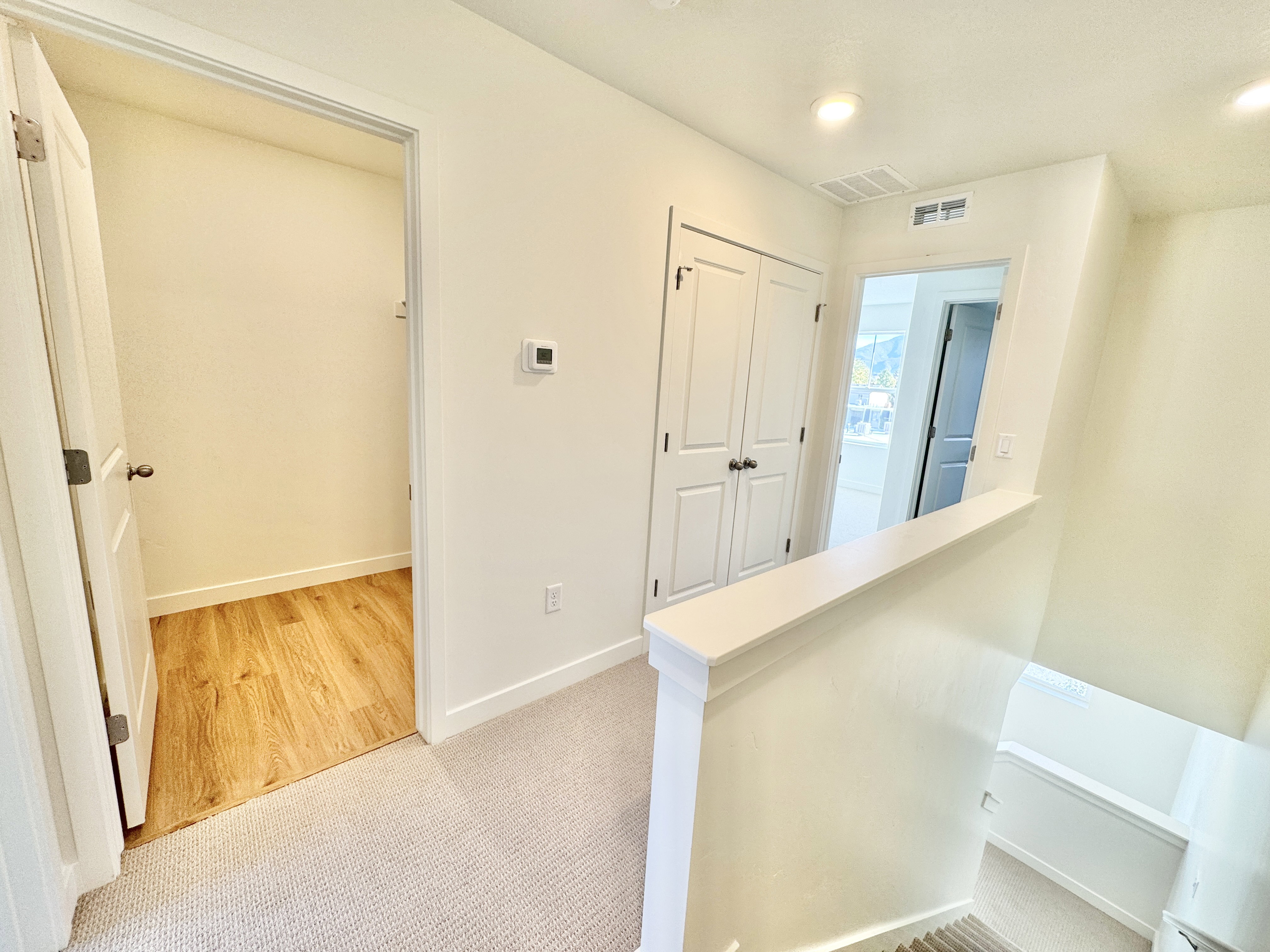 Upper-level hallway featuring neutral carpeting, white trim, and recessed lighting