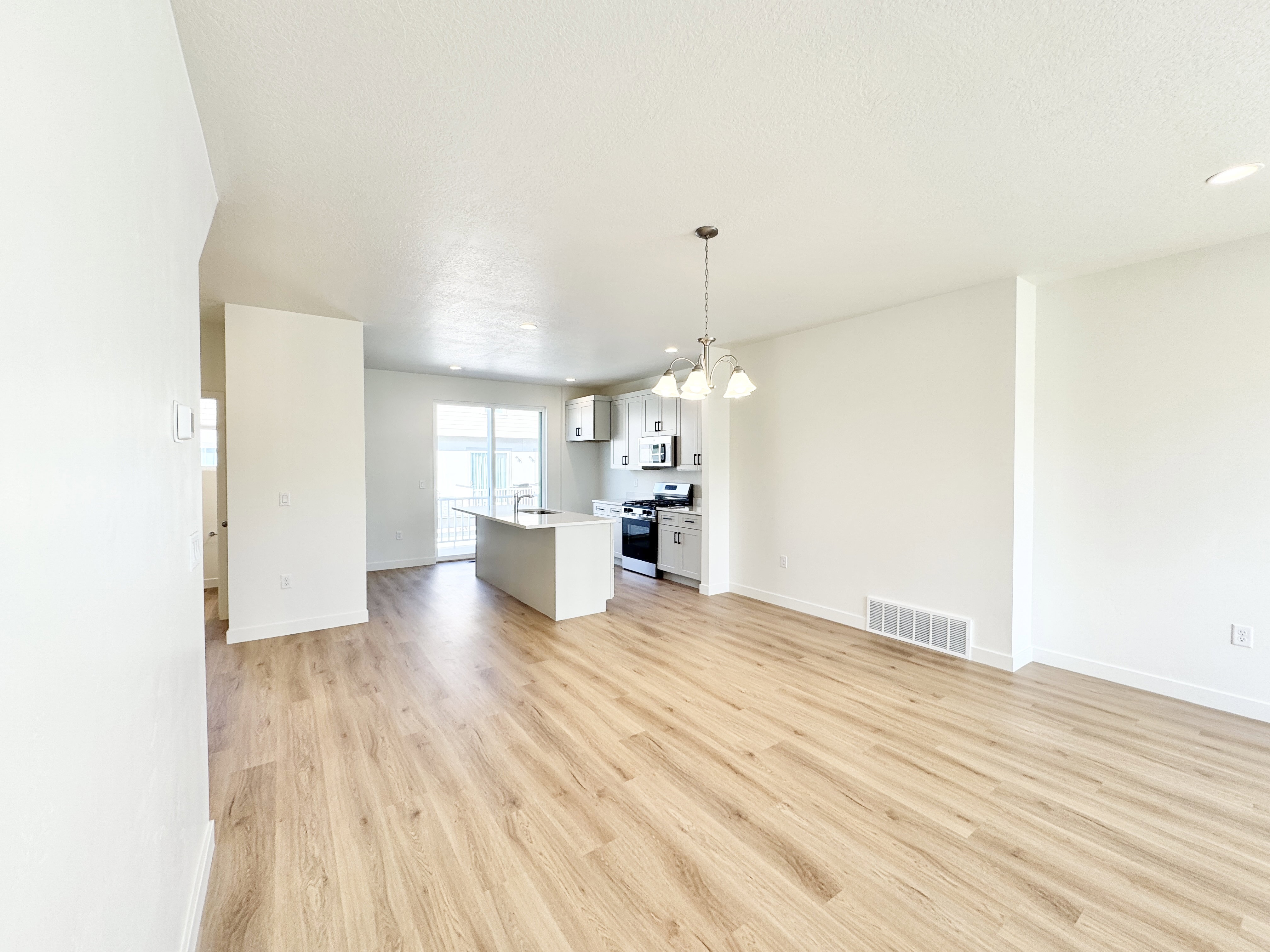 Open-concept living space featuring wood-finish flooring, white walls, and recessed lighting