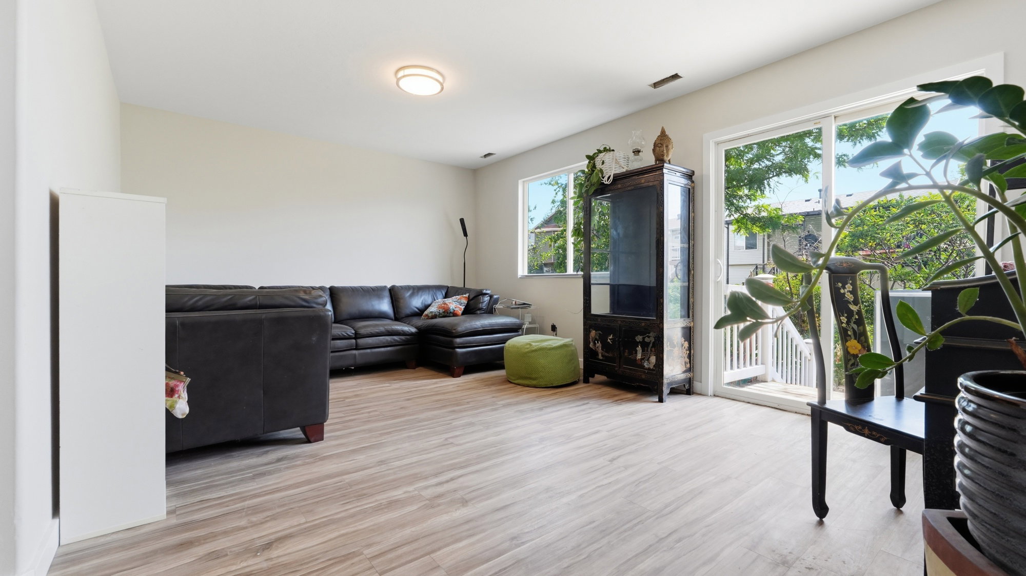 Bright interior space featuring light wood-finish flooring, white walls, and a contemporary flush-mount ceiling light