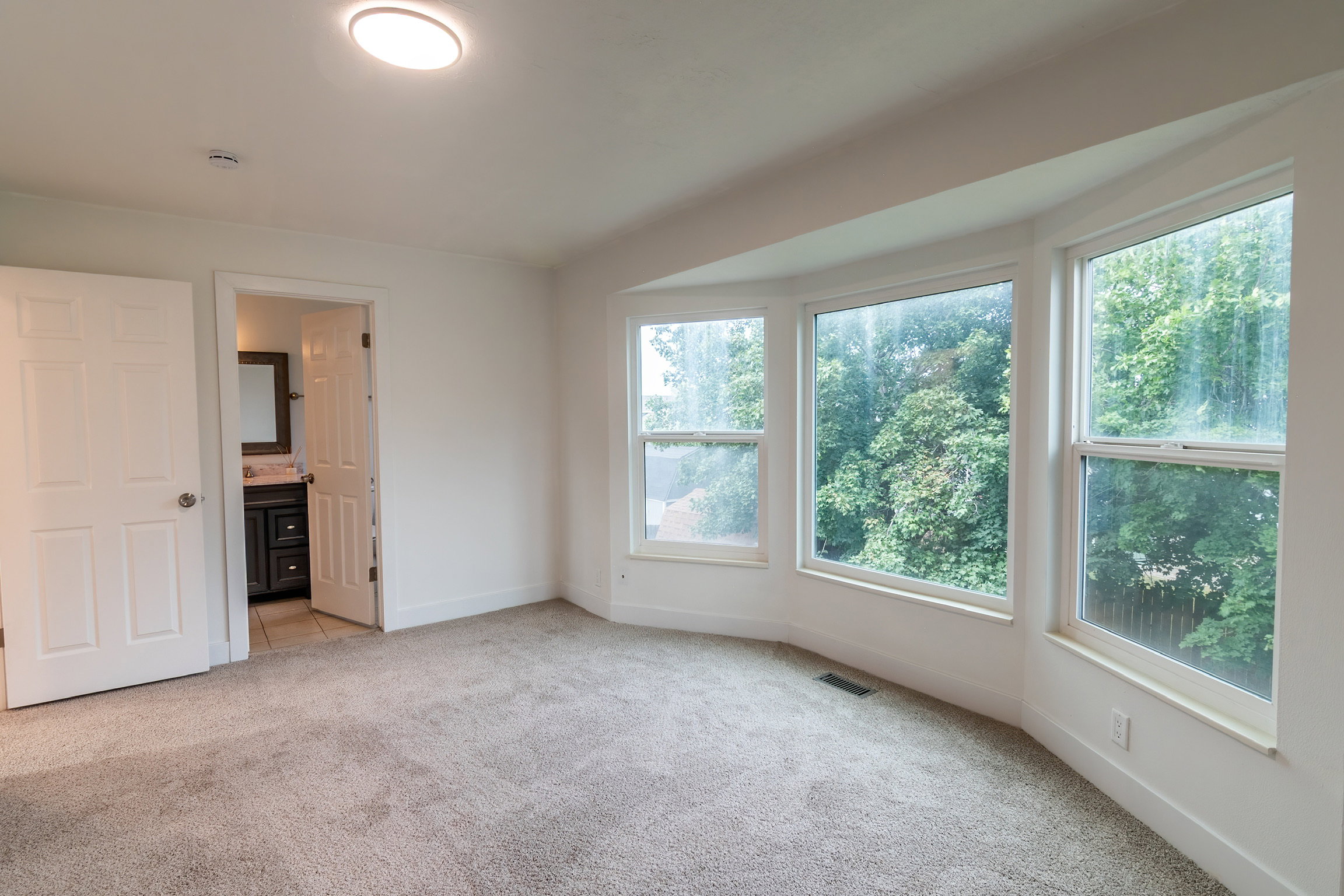 Spacious room featuring a bay window with multiple panes, providing ample natural light