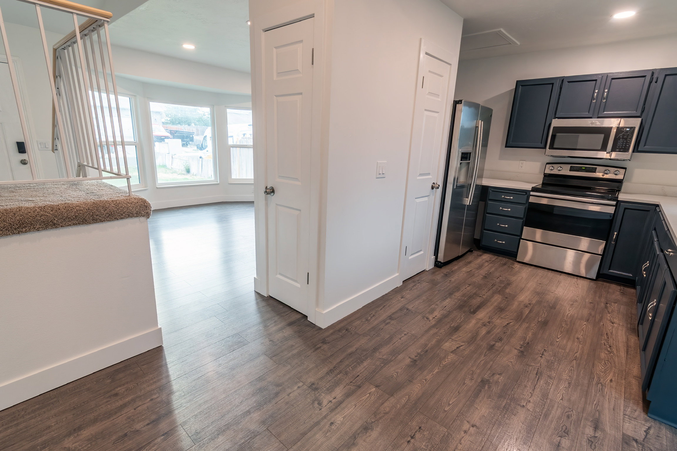 Open-concept living area with wood-finish flooring extending into the kitchen