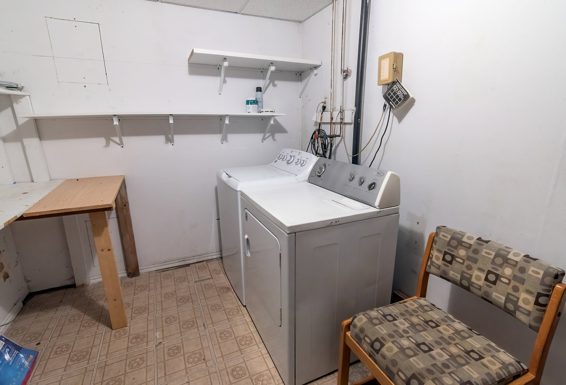 Dedicated laundry area featuring a white washing machine, white dryer, and wall-mounted shelving