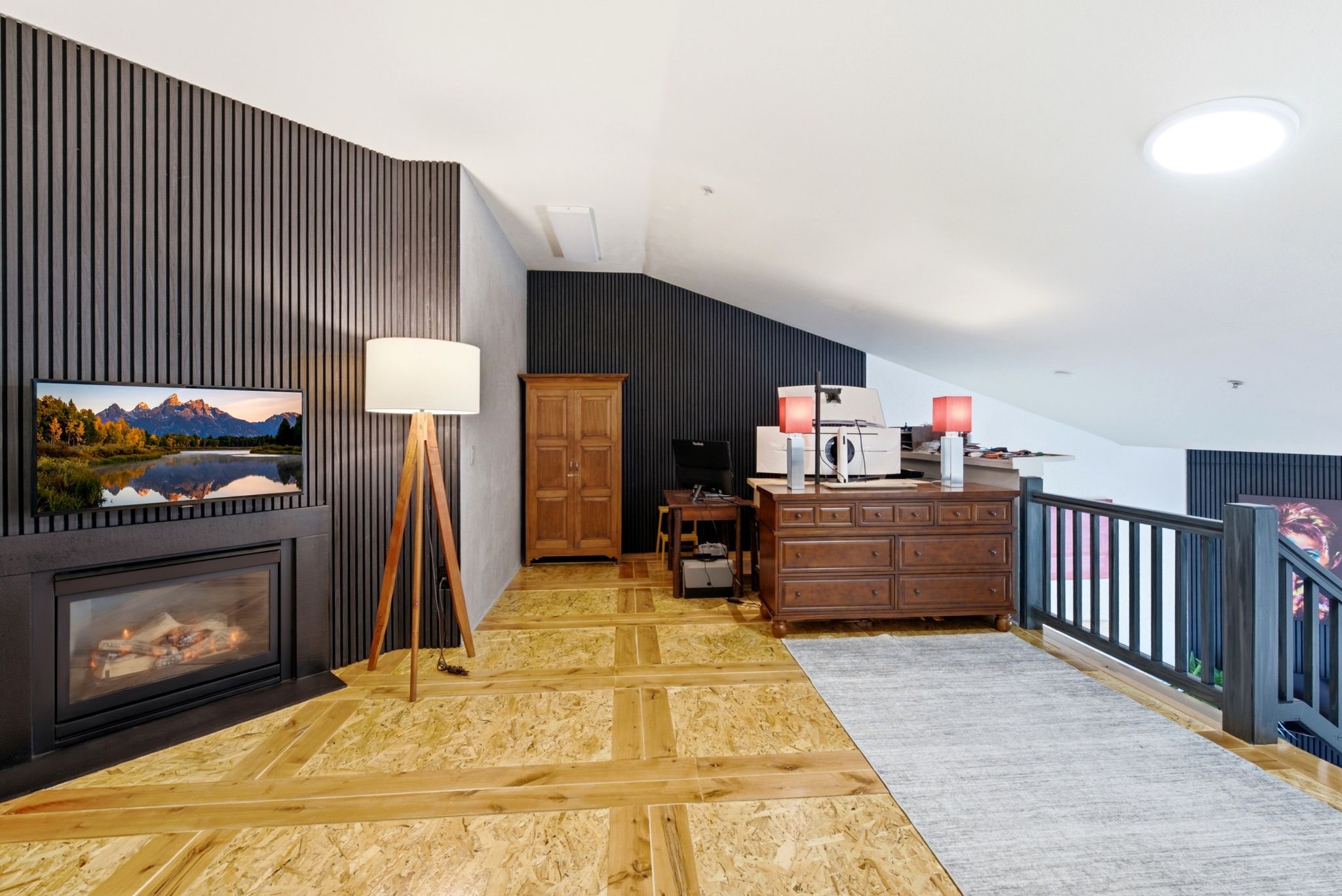 Angled wall featuring slatted paneling, a built-in fireplace, and a television recess