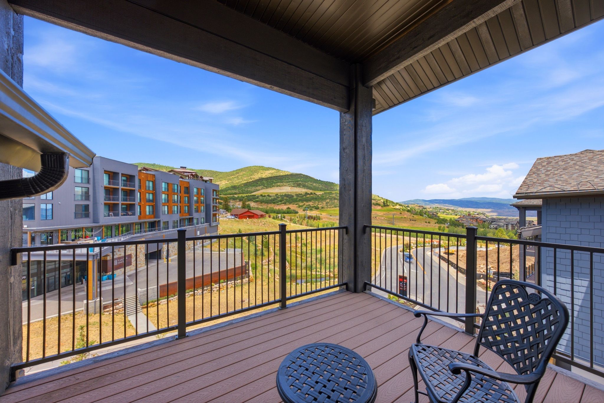 Covered balcony featuring composite decking and black metal railings