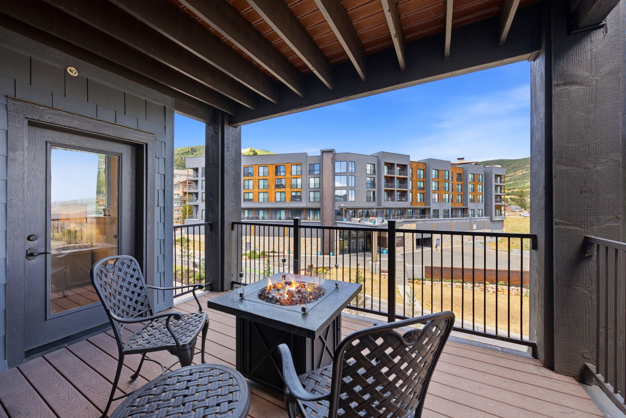 Private balcony featuring composite decking and a built-in fire pit
