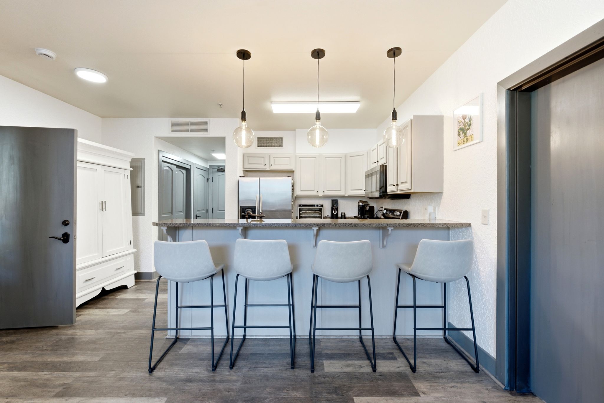 Kitchen featuring light cabinetry, stainless steel appliances, and a breakfast bar with pendant lighting