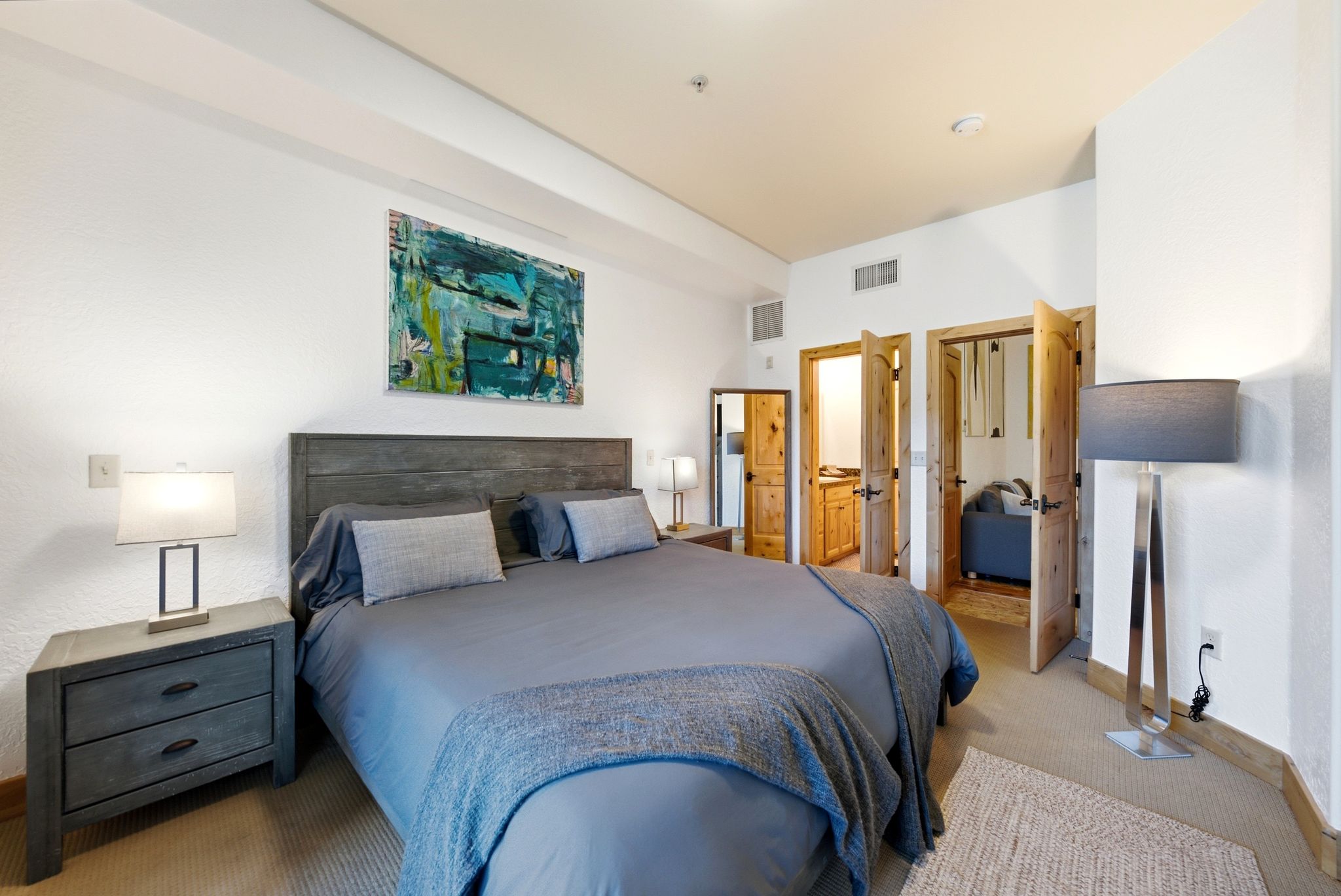 Neutral bedroom featuring carpet flooring, built-in recessed lighting, and a wood-finish headboard