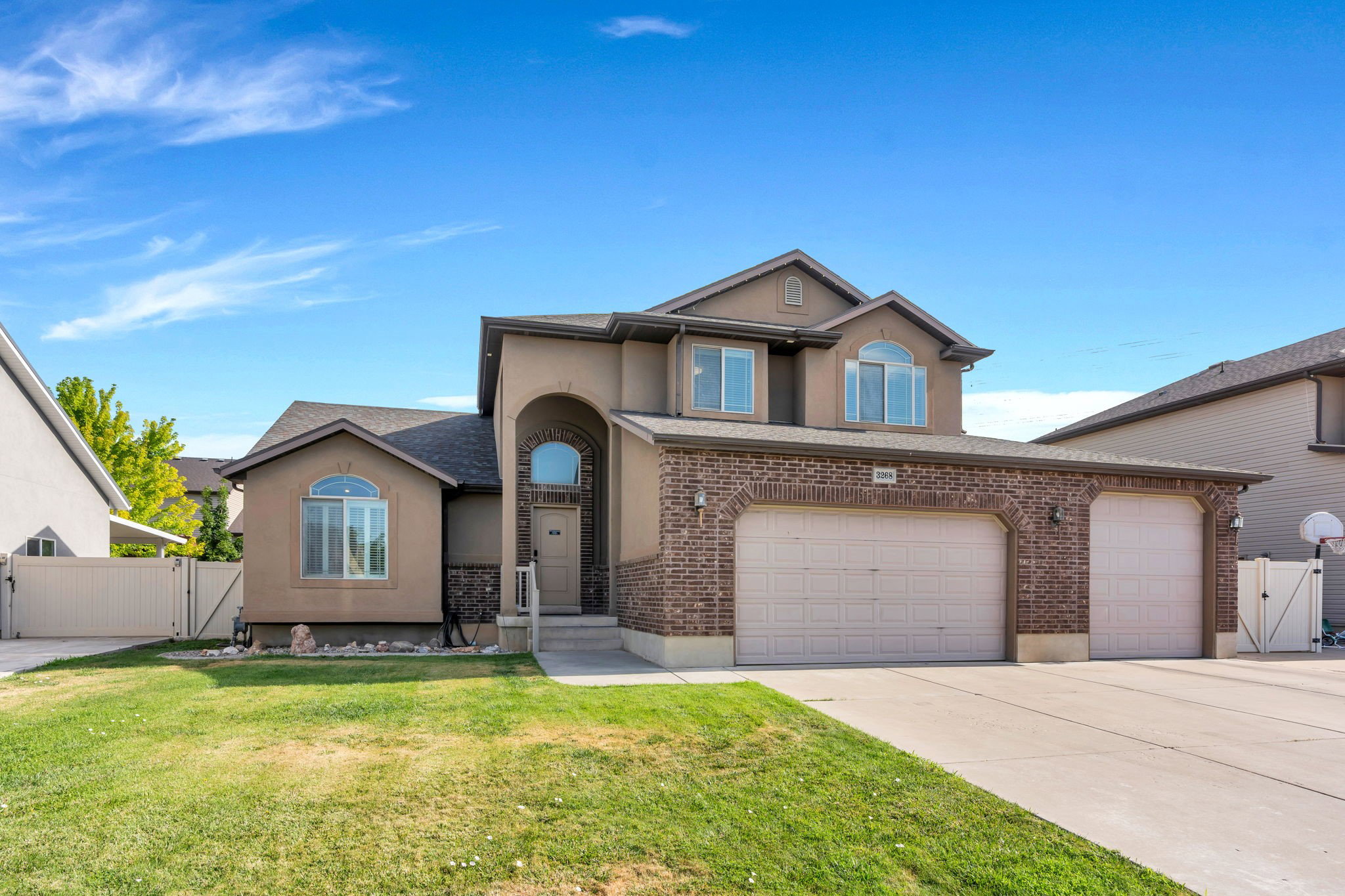 Stucco and brick exterior with arched entryway and multiple arched windows