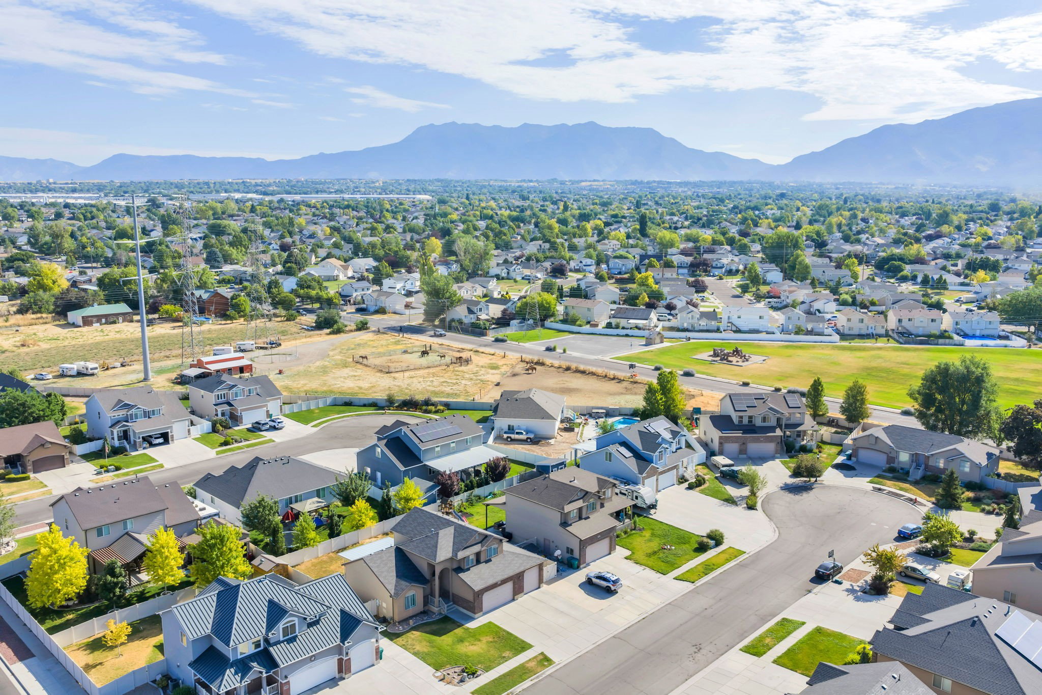 Aerial perspective showcasing a residential neighborhood with mountain backdrop