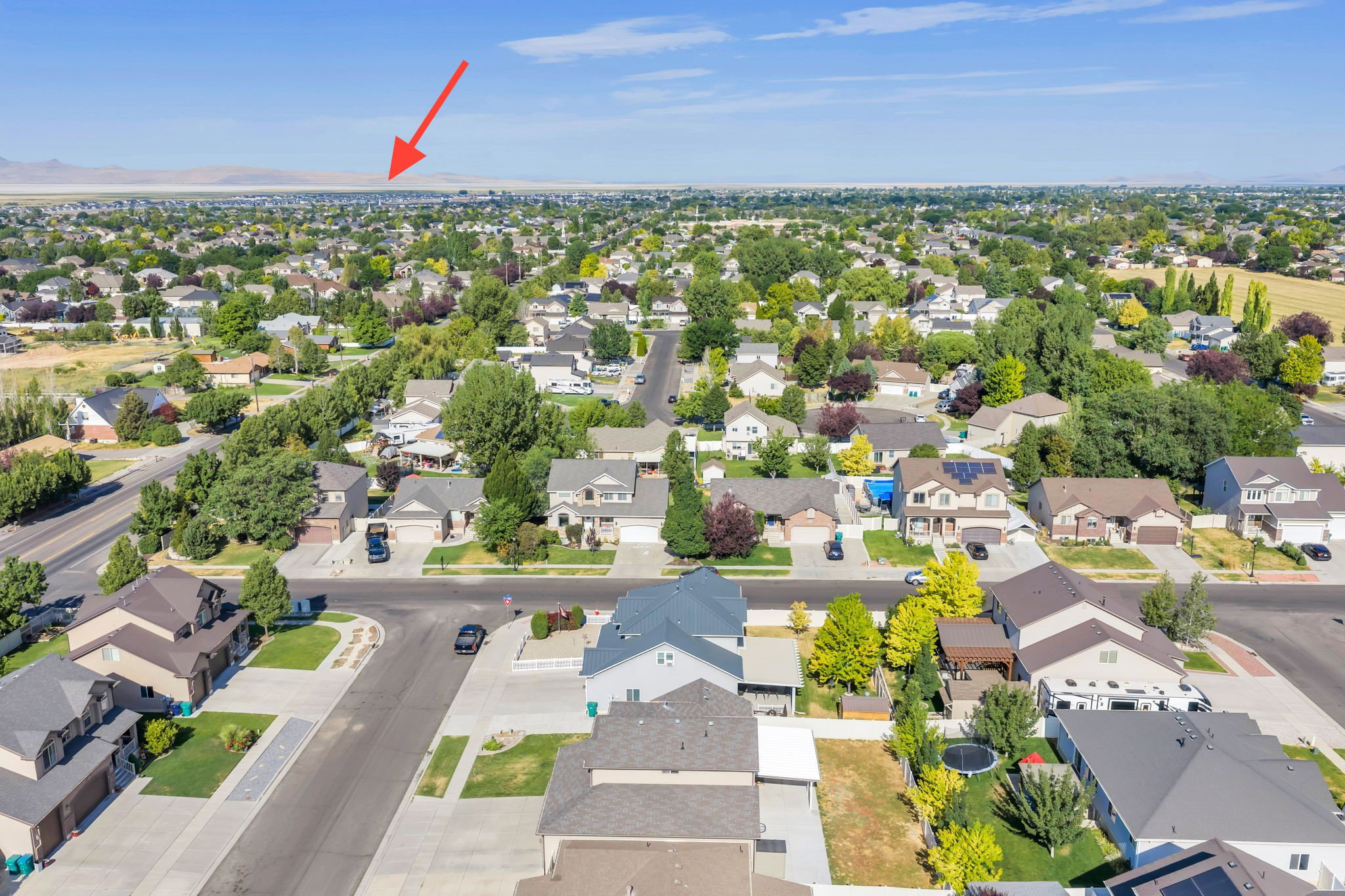 Expansive aerial perspective showcasing a residential neighborhood with numerous single-family homes and mature trees