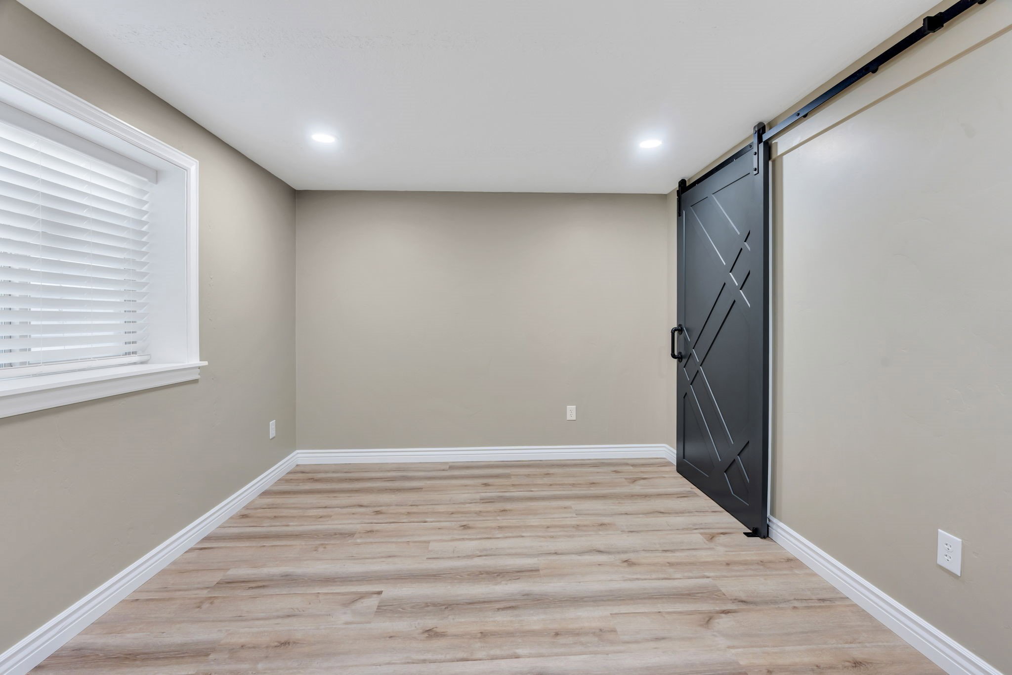 Room featuring a prominent black barn door with geometric detailing