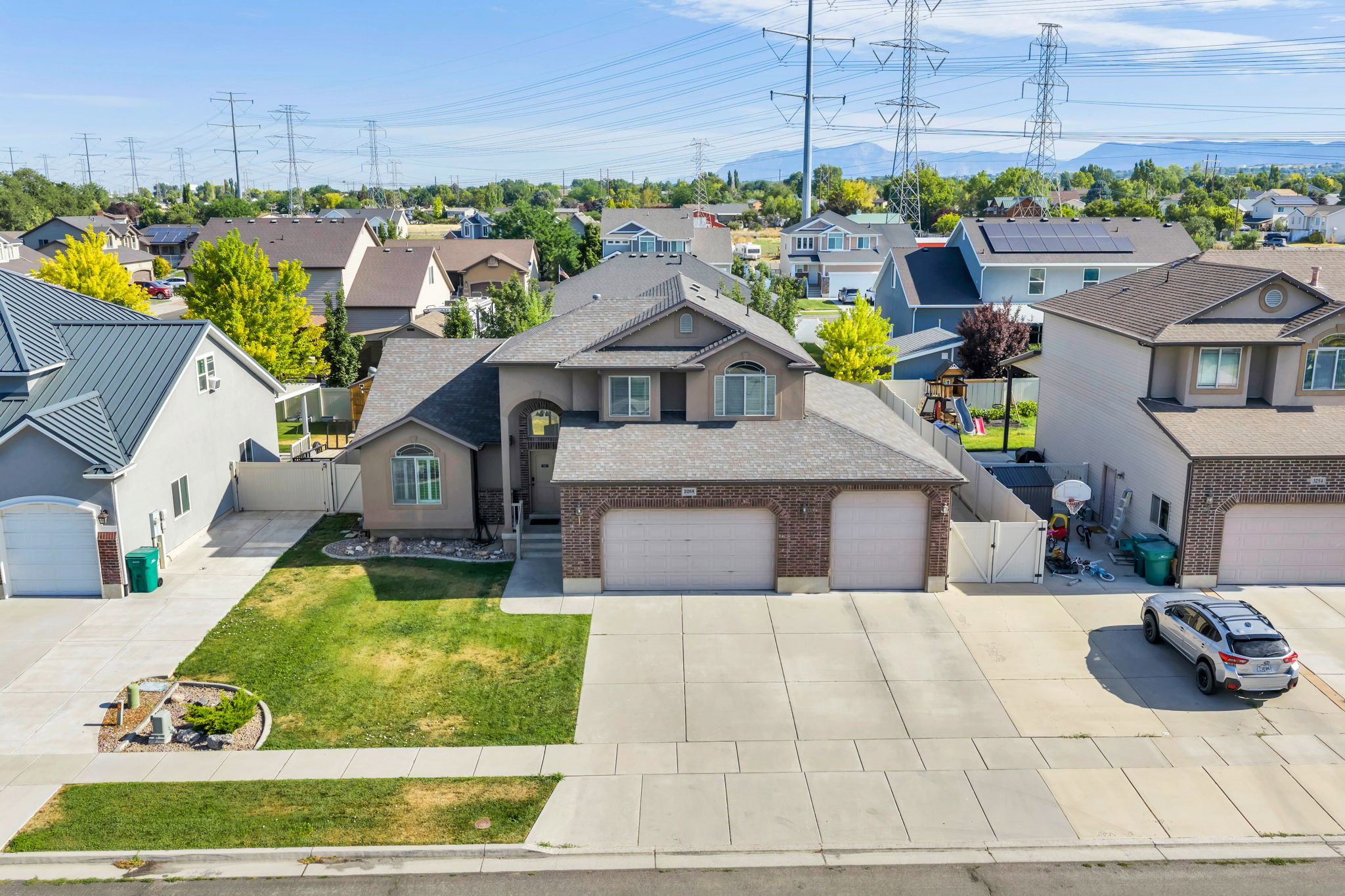 Two-story residence featuring a brick and stucco facade, a two-car garage, an arched entry, and a paved driveway