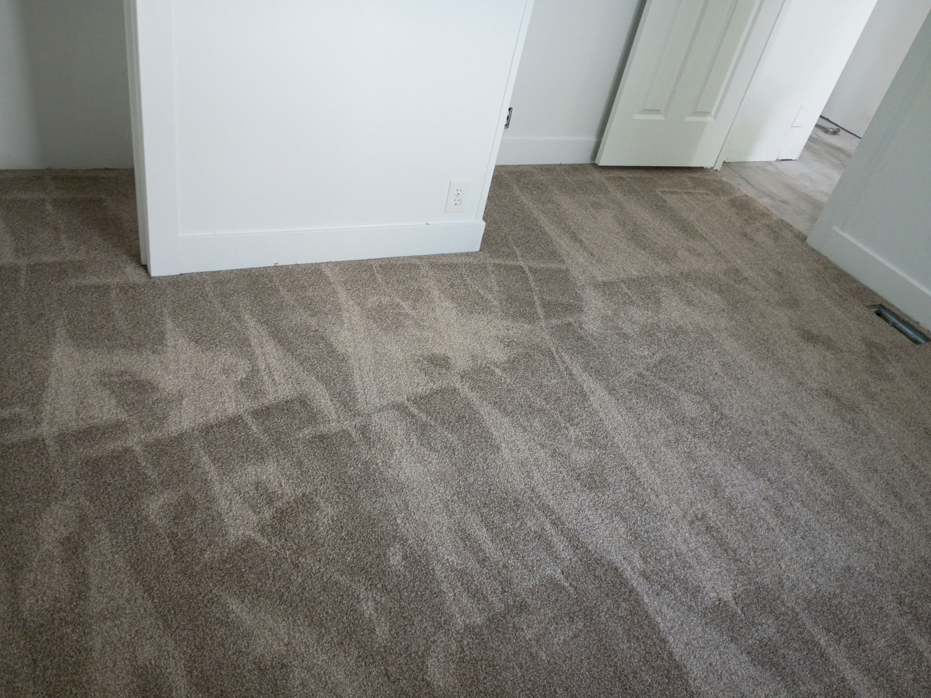 Wall-to-wall carpeting in a neutral tone, complemented by white baseboards and trim