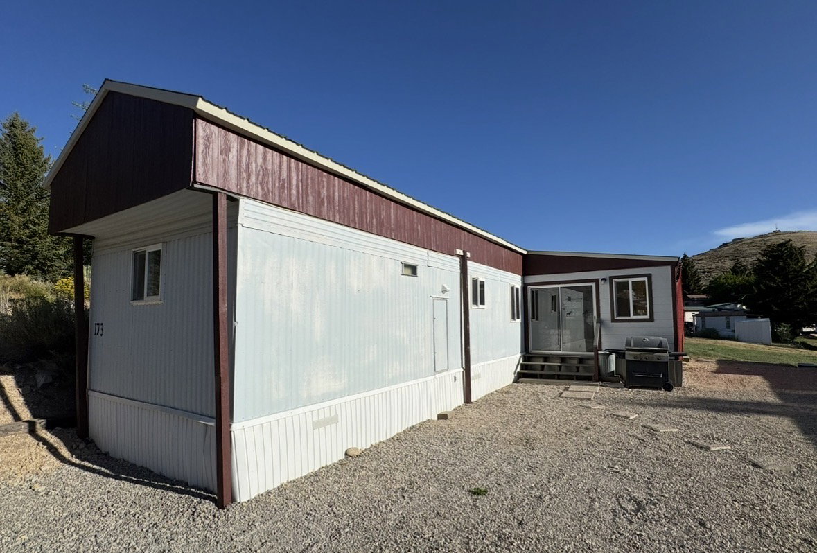 Light blue siding exterior with dark red trim and gable roofline