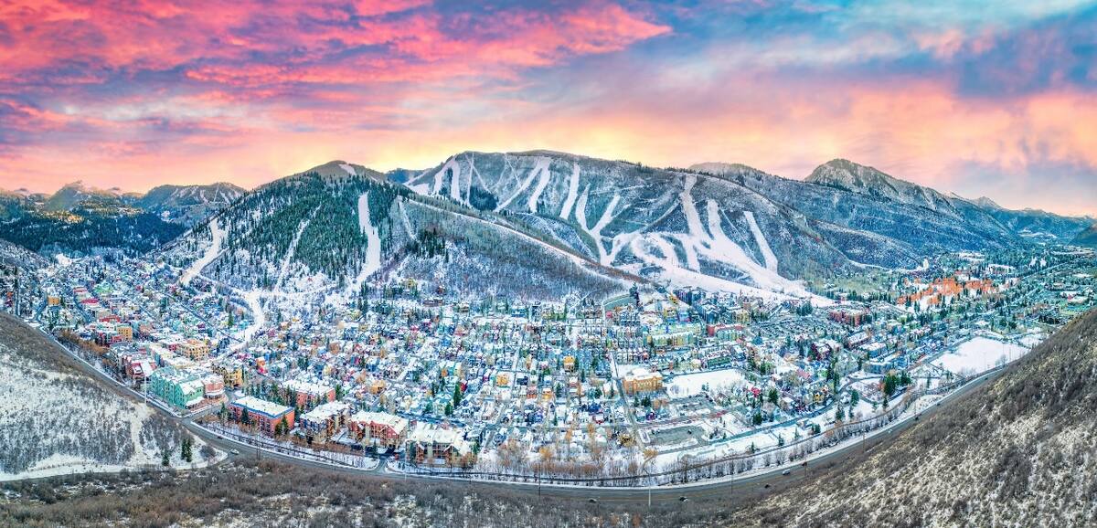 Snow-covered mountain town with extensive residential areas and commercial buildings nestled in a valley