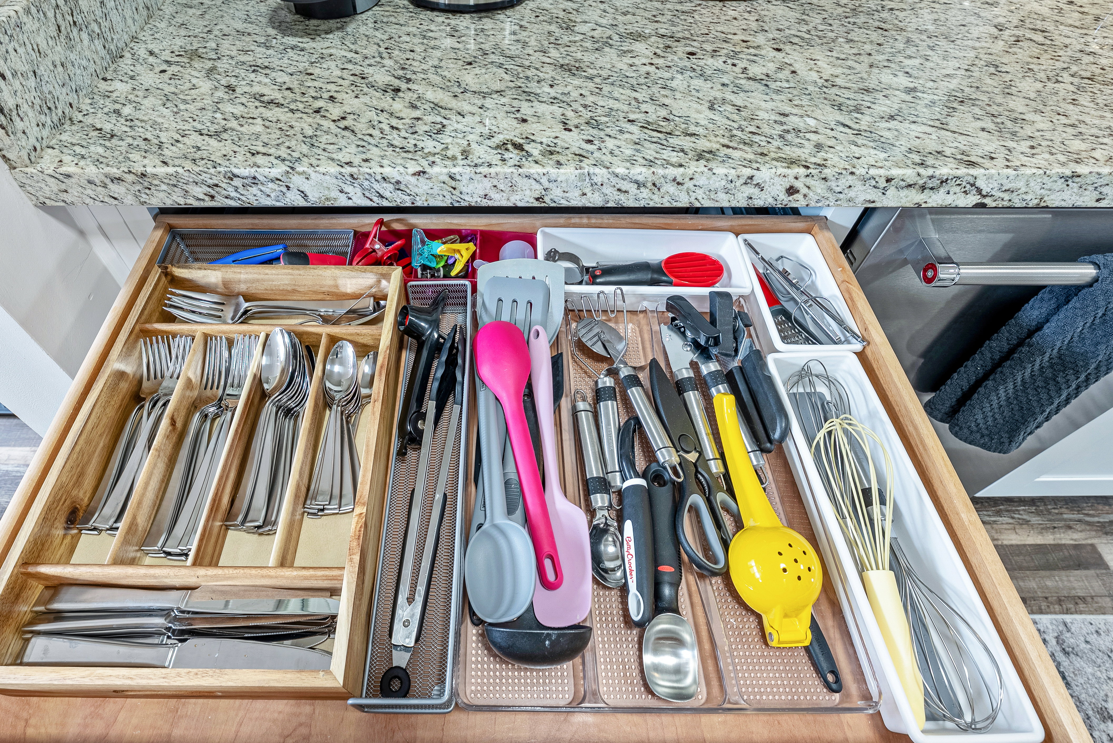 Kitchen drawer with integrated wooden cutlery organizer and assorted utensil storage