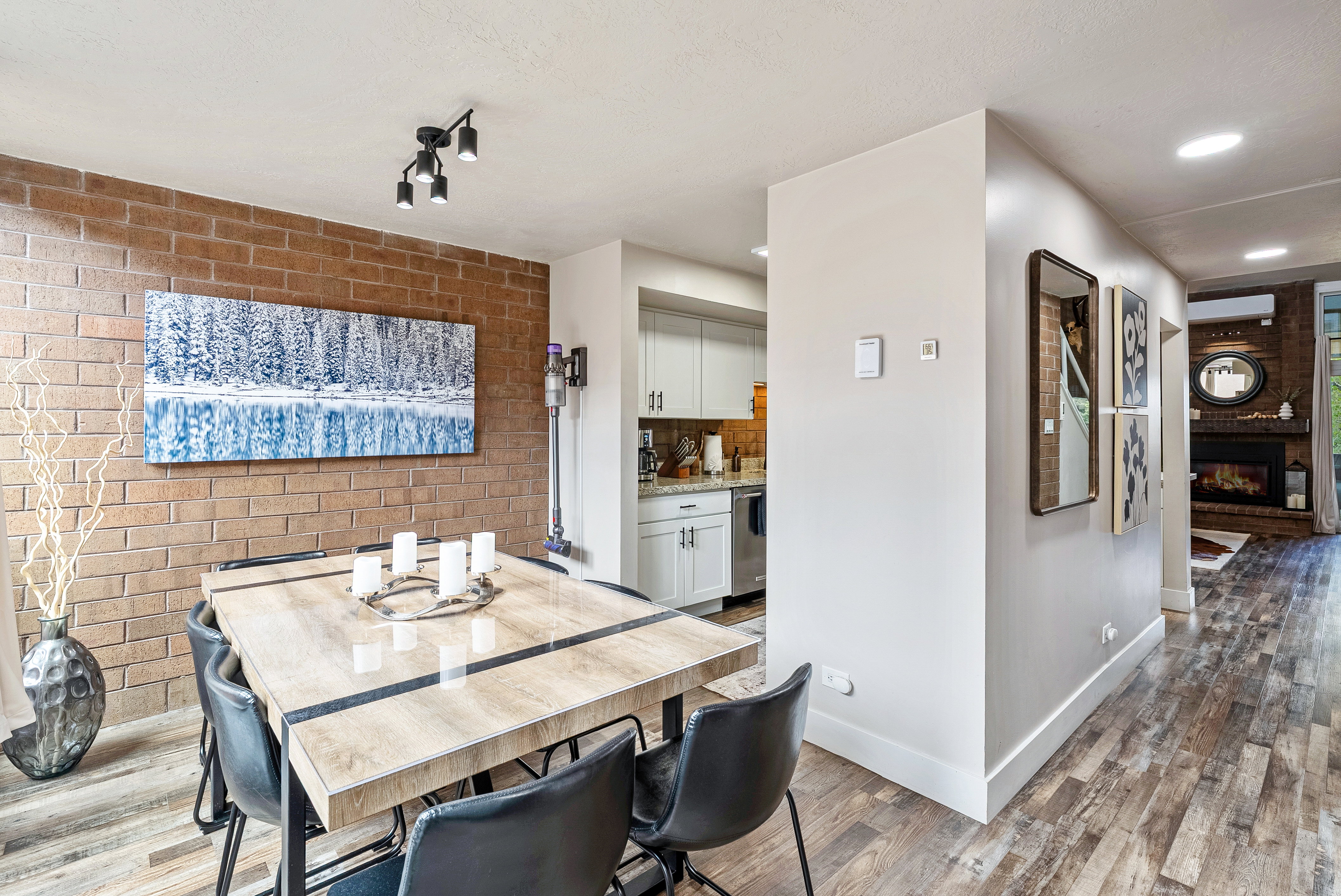 Dining area featuring a brick accent wall, wood-finish flooring, and recessed lighting