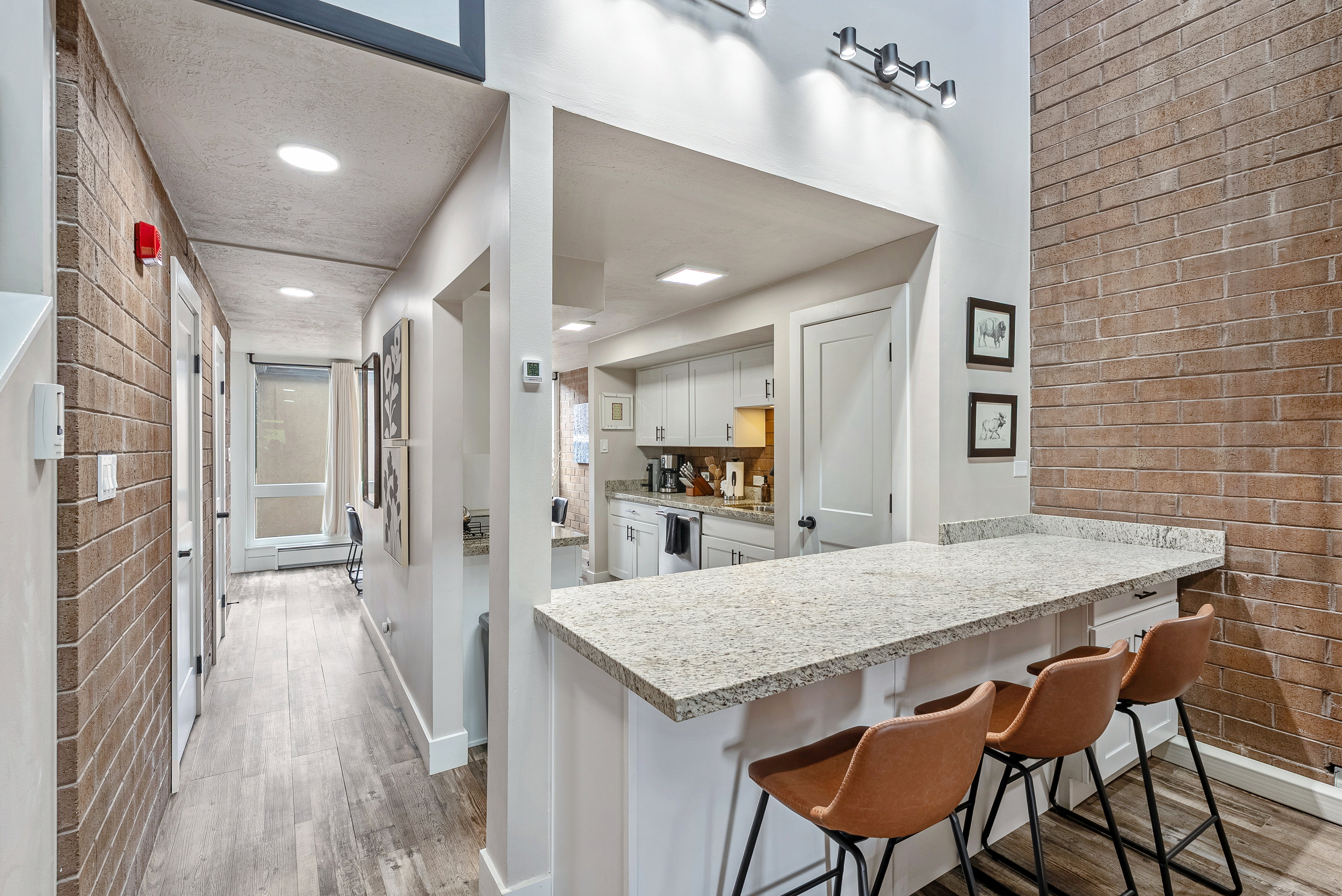 Kitchen featuring light cabinetry, a peninsula with a stone countertop, and recessed lighting