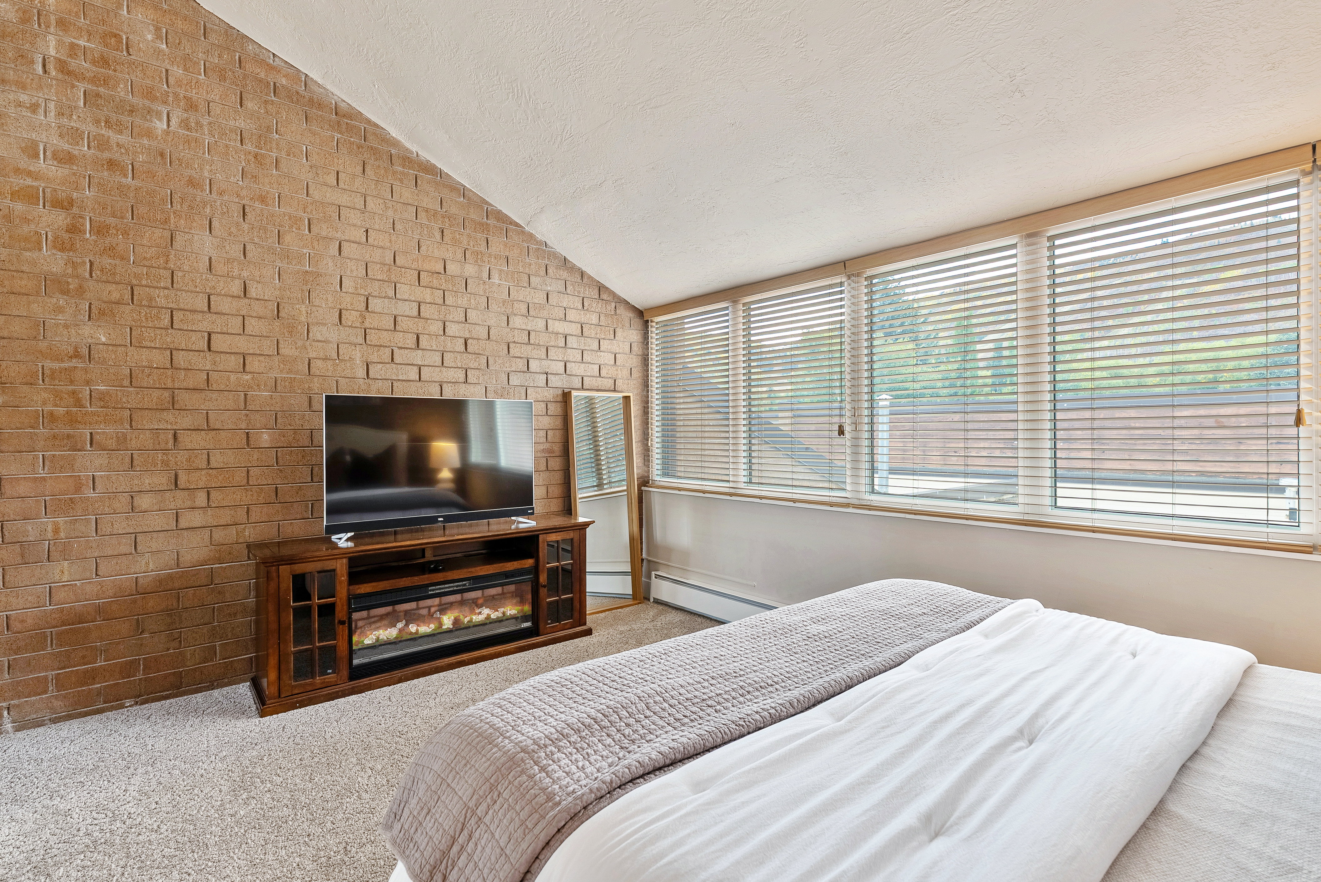 Interior brick accent wall with a vaulted ceiling