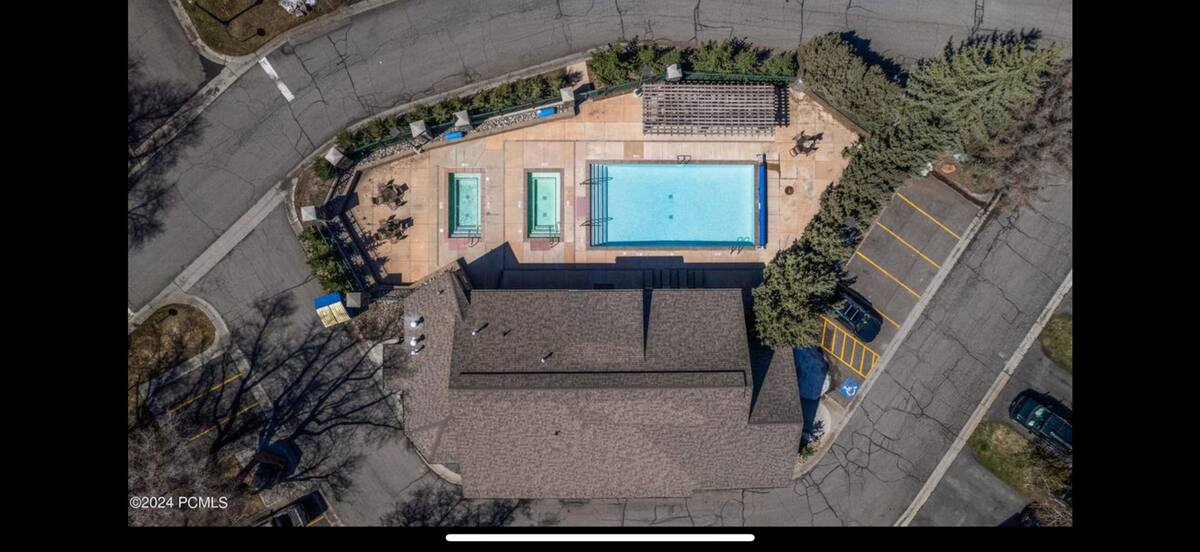 Community recreation area featuring a large swimming pool, two smaller pools, and a pergola-covered patio