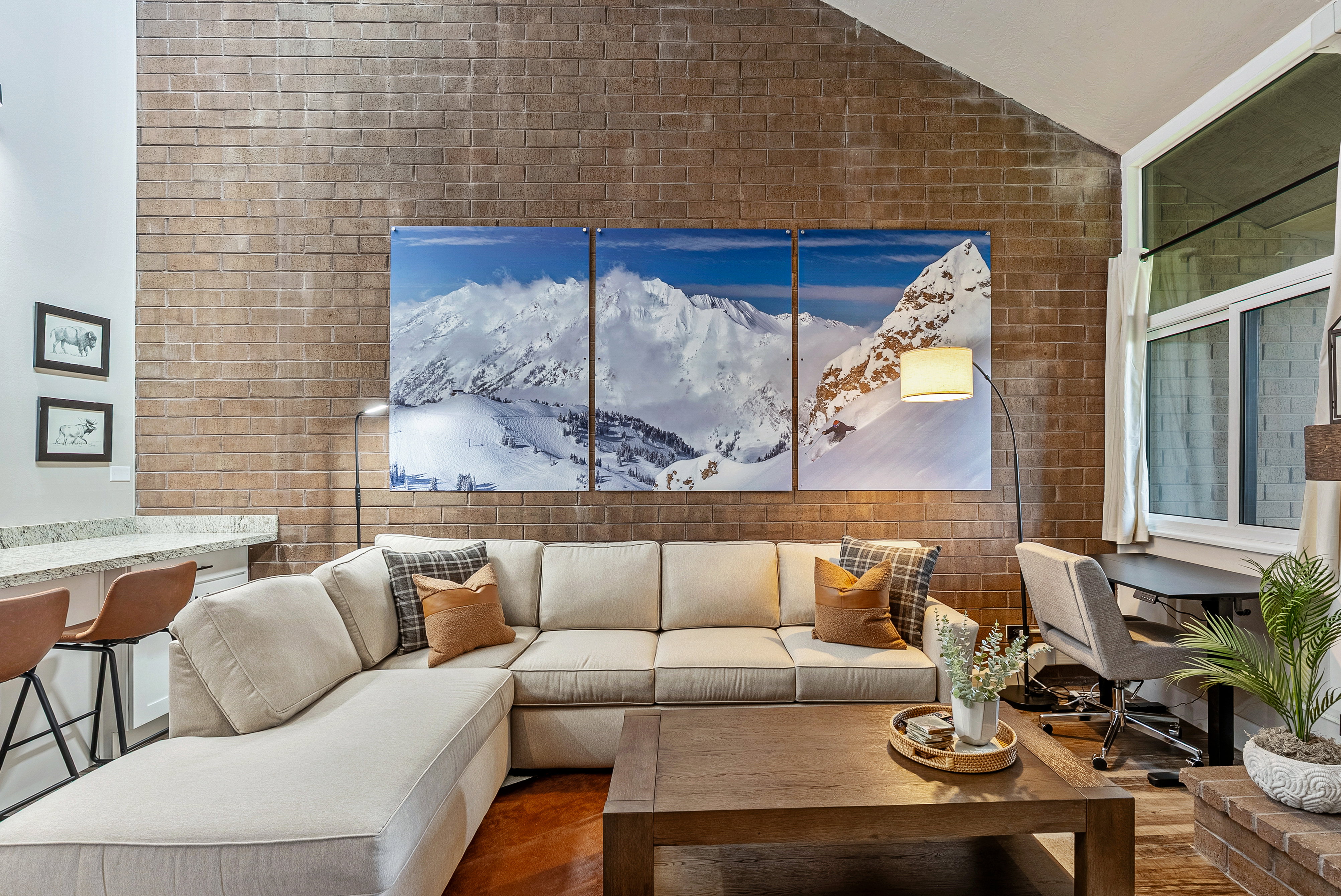 Exposed brick wall accenting a spacious living area with vaulted ceilings