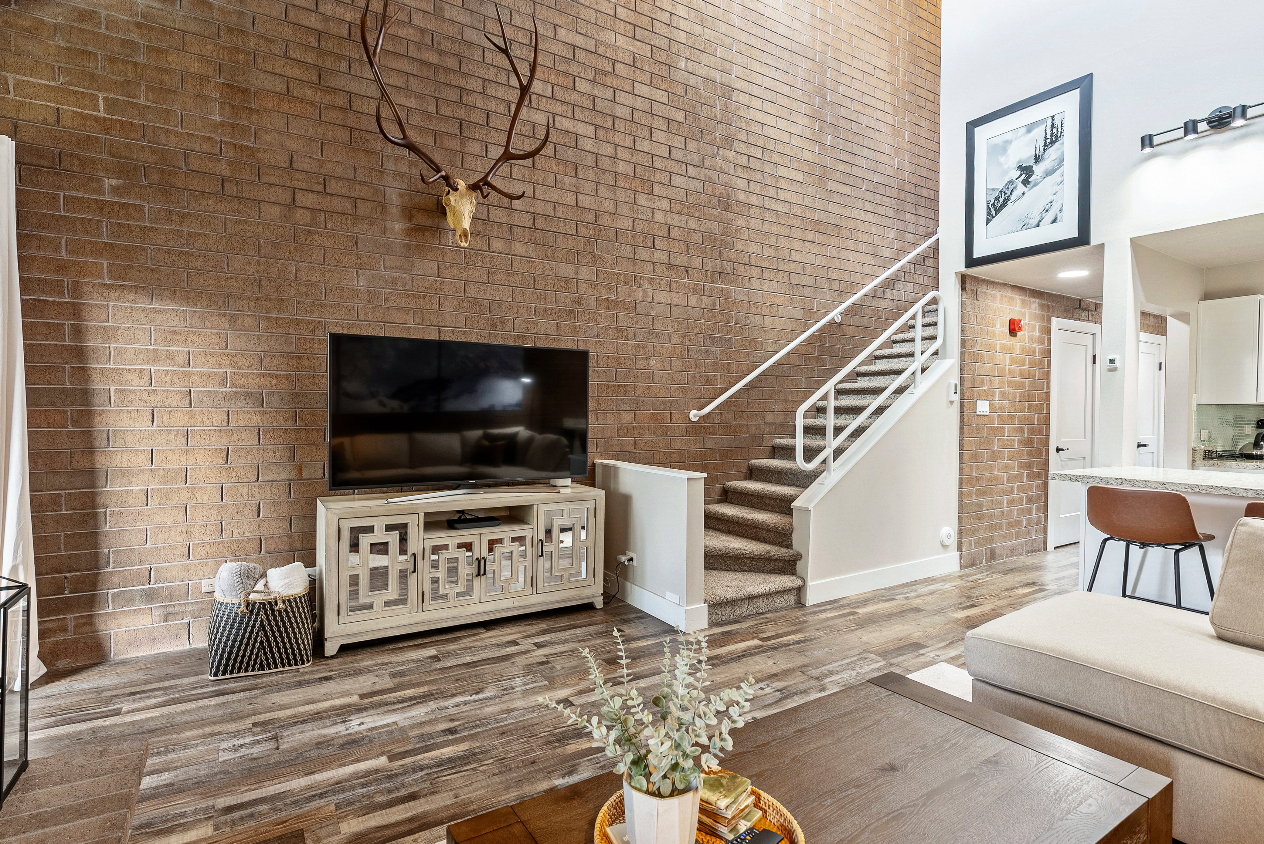 Two-story brick accent wall with wood-finish flooring