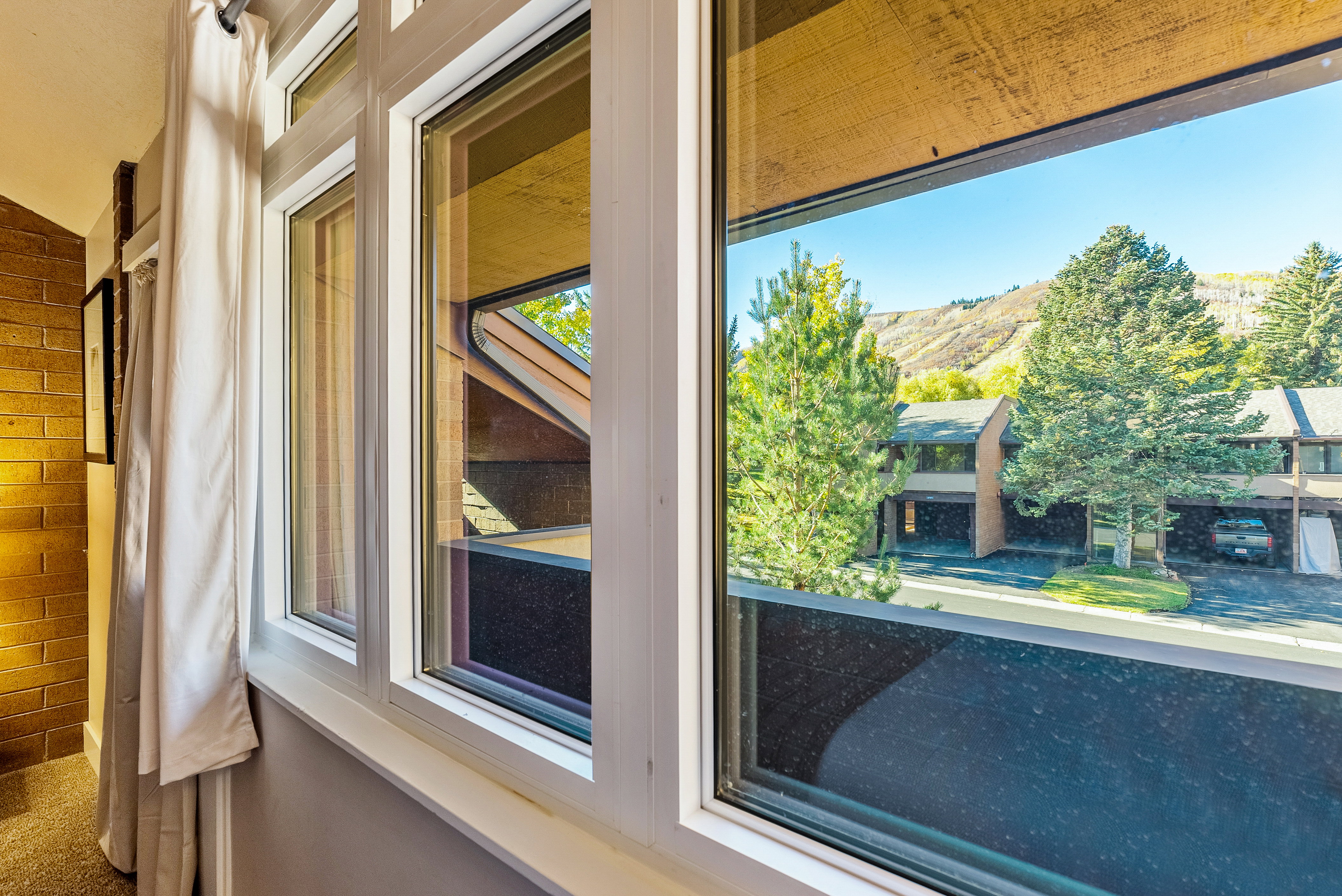 Multiple windows with white frames offer expansive mountain scenery