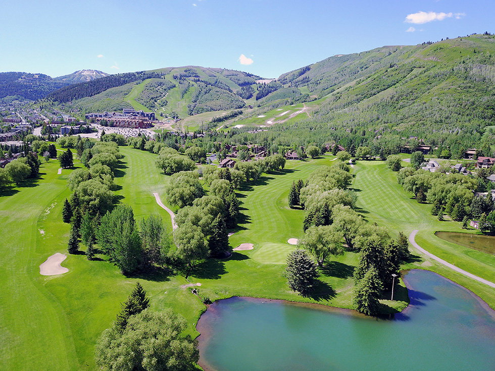 Expansive golf course setting featuring lush green fairways and mature trees