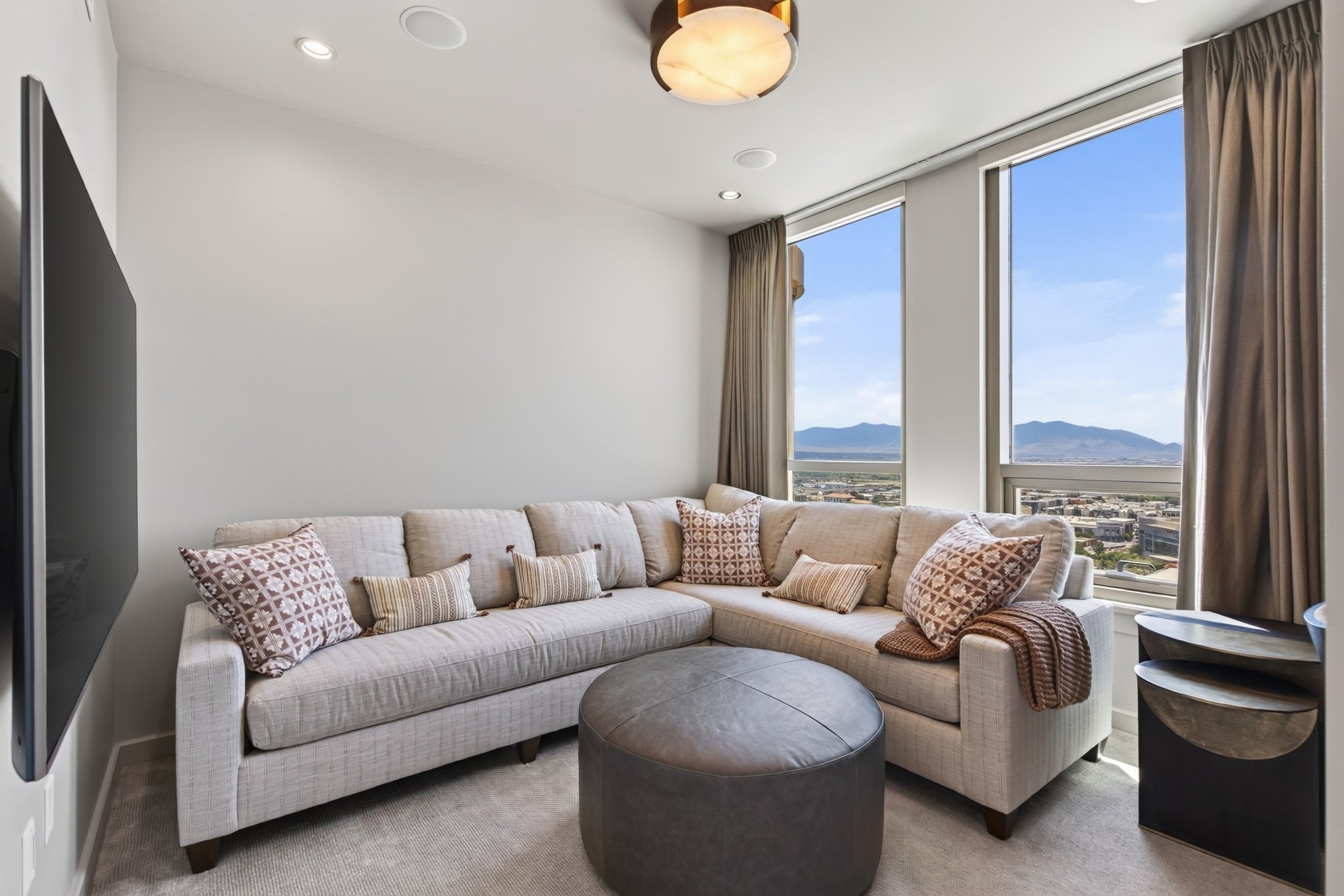 Living area featuring expansive windows with mountain and city scenery