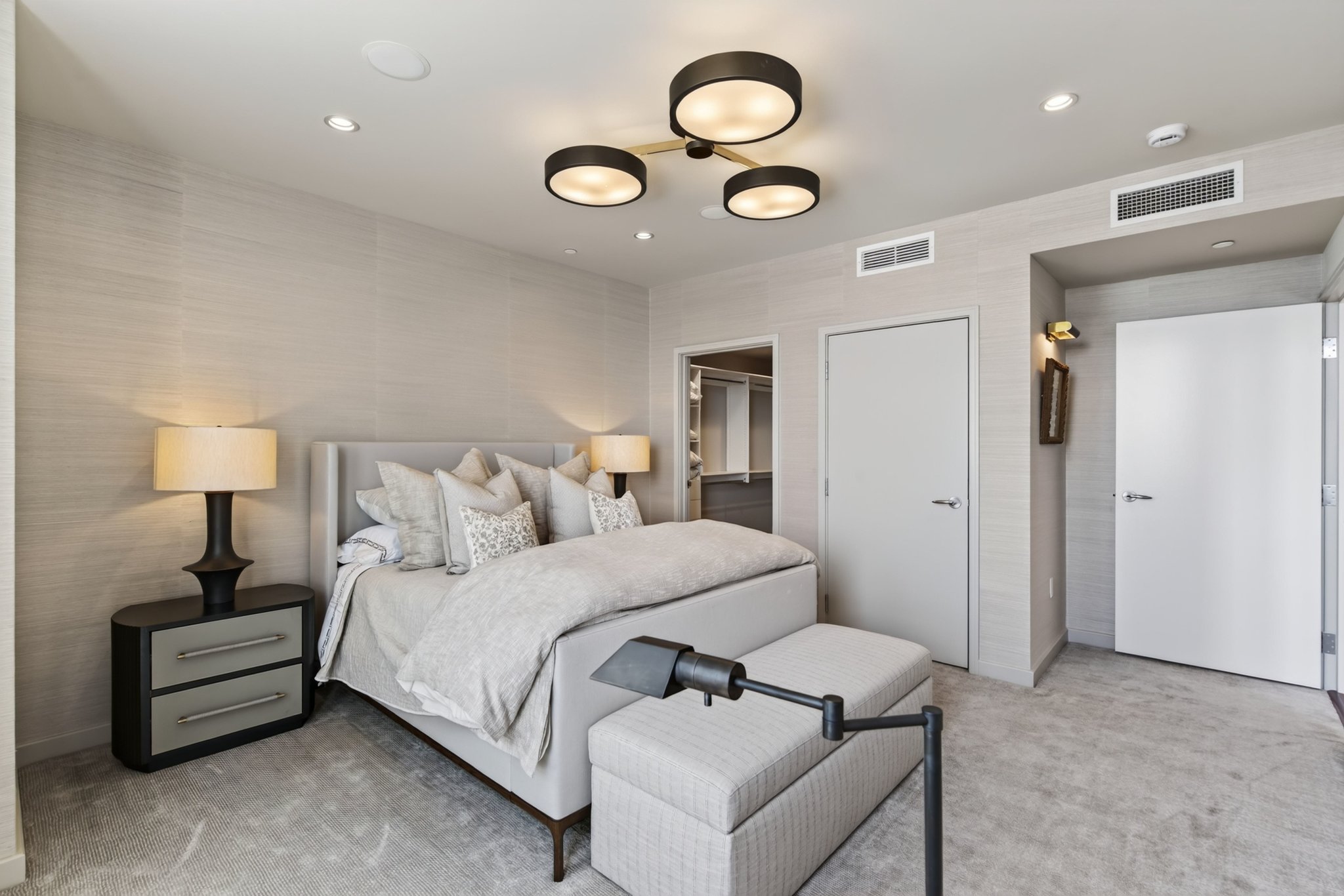 Neutral-toned bedroom featuring recessed lighting and a central contemporary chandelier