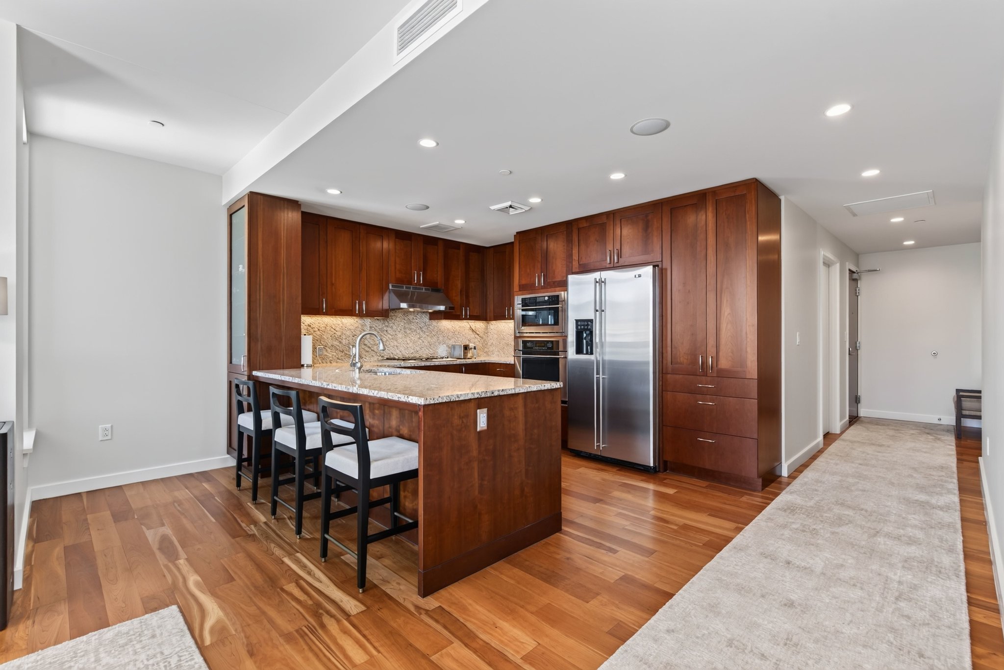 Kitchen featuring rich wood cabinetry, stainless steel appliances, and a central island with a light-toned countertop