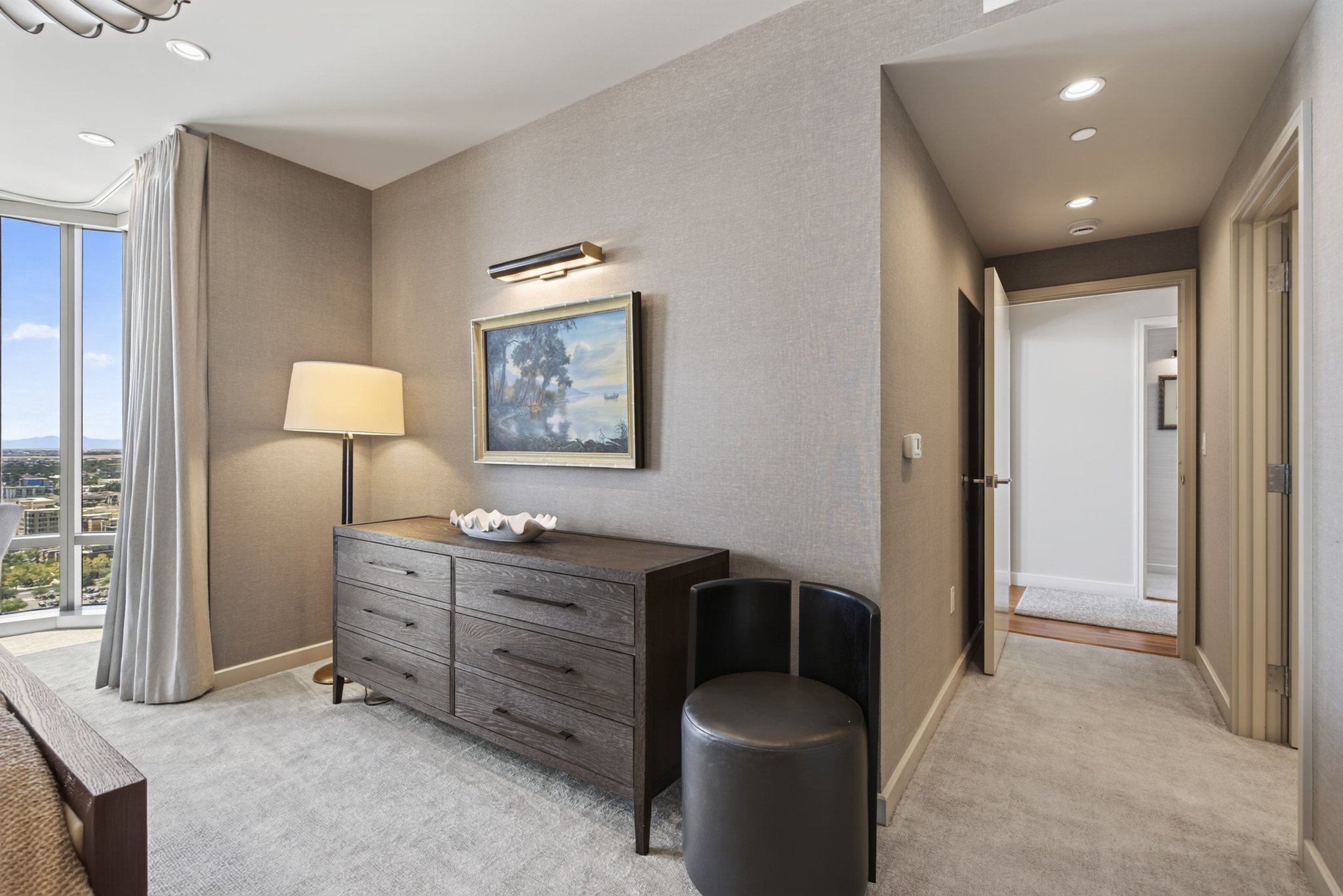 Wall-to-wall carpeting throughout this space with a full-height window featuring vertical drapes