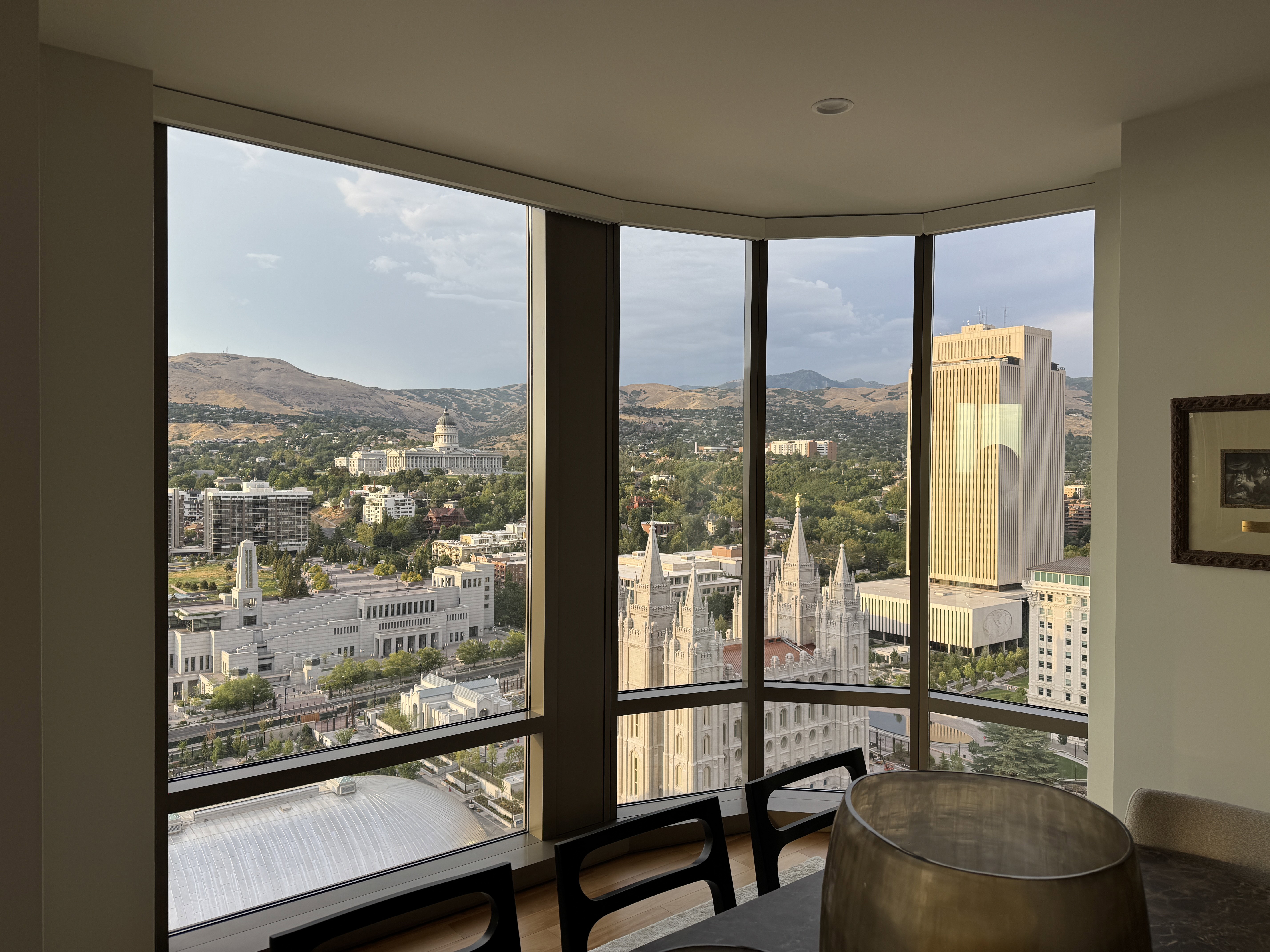 Expansive corner windows showcasing city and mountain landscapes