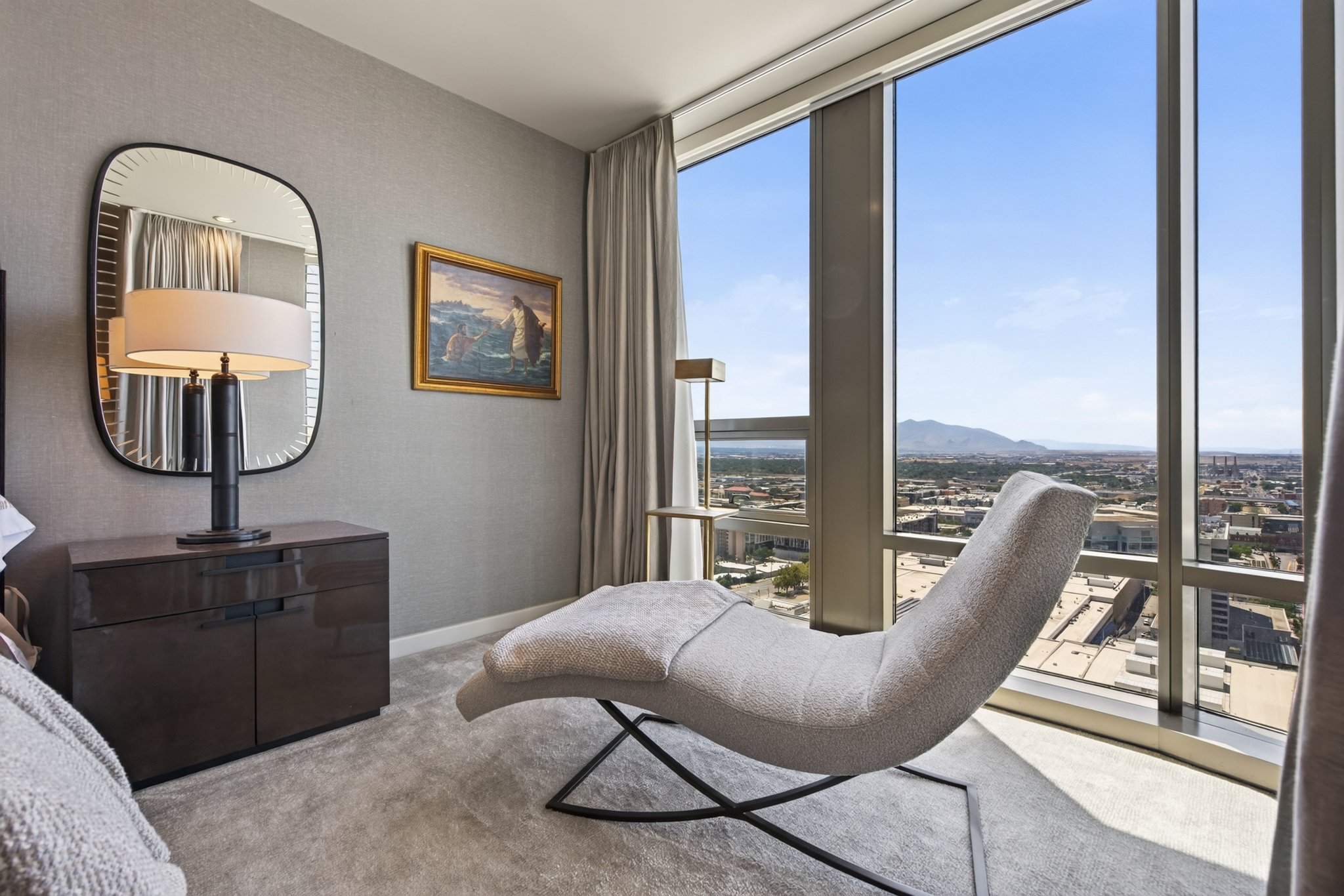Floor-to-ceiling windows with expansive city and mountain scenery