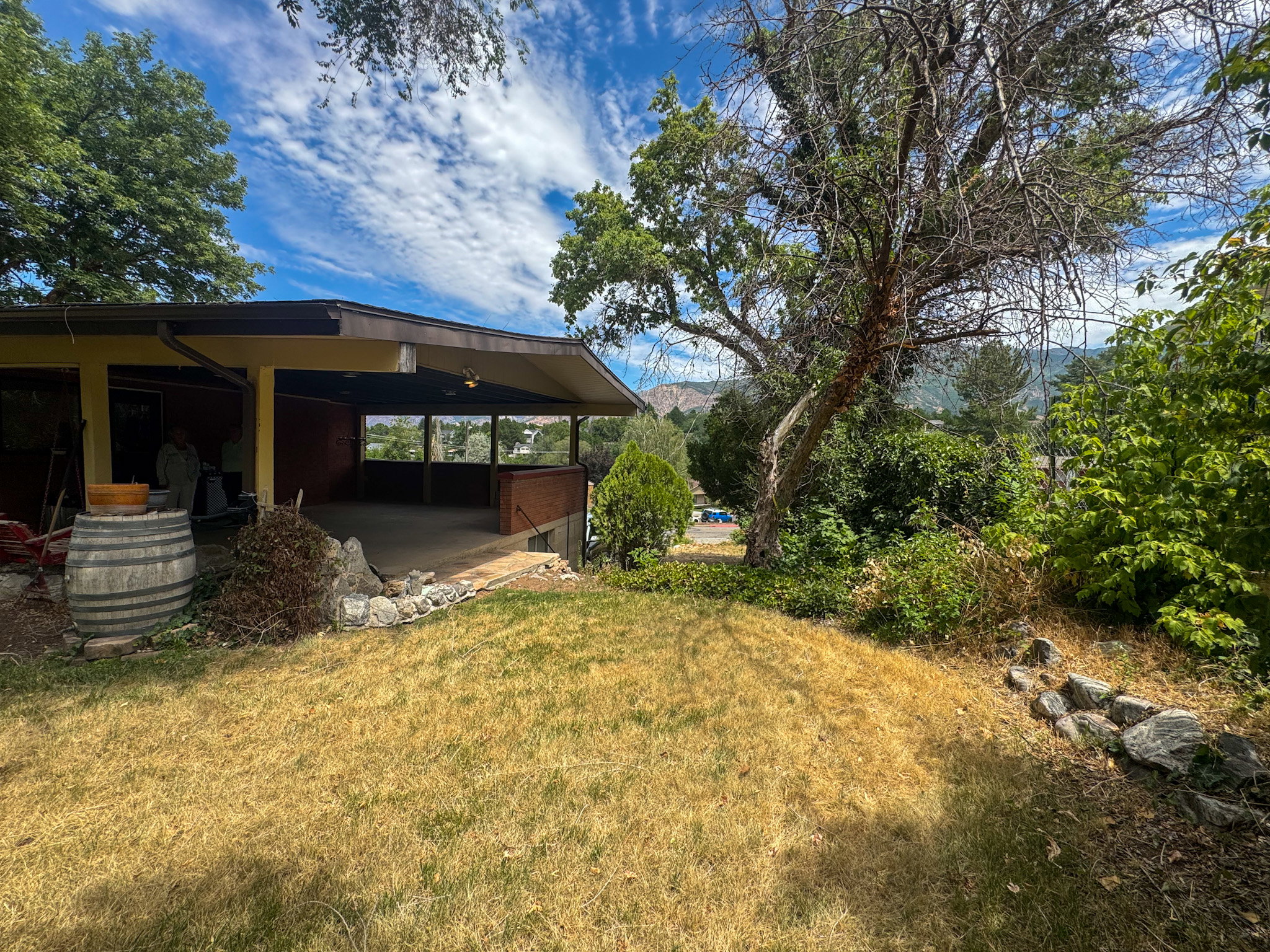 Covered patio with concrete flooring, supported by columns, and featuring an exterior railing