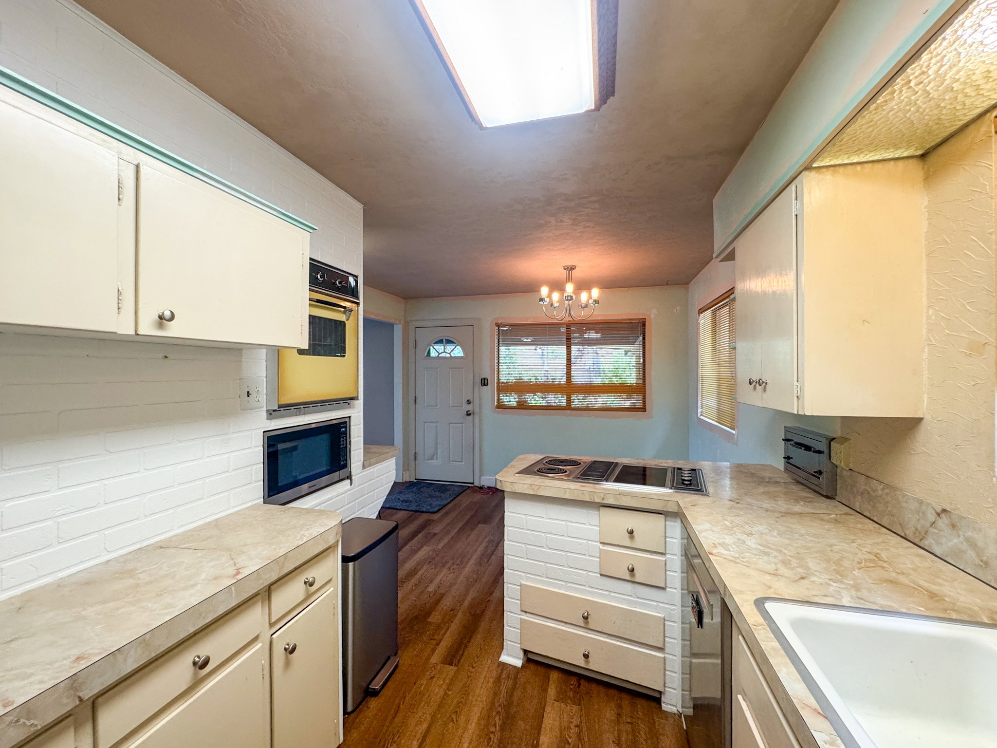Kitchen featuring wood-finish flooring and a skylight