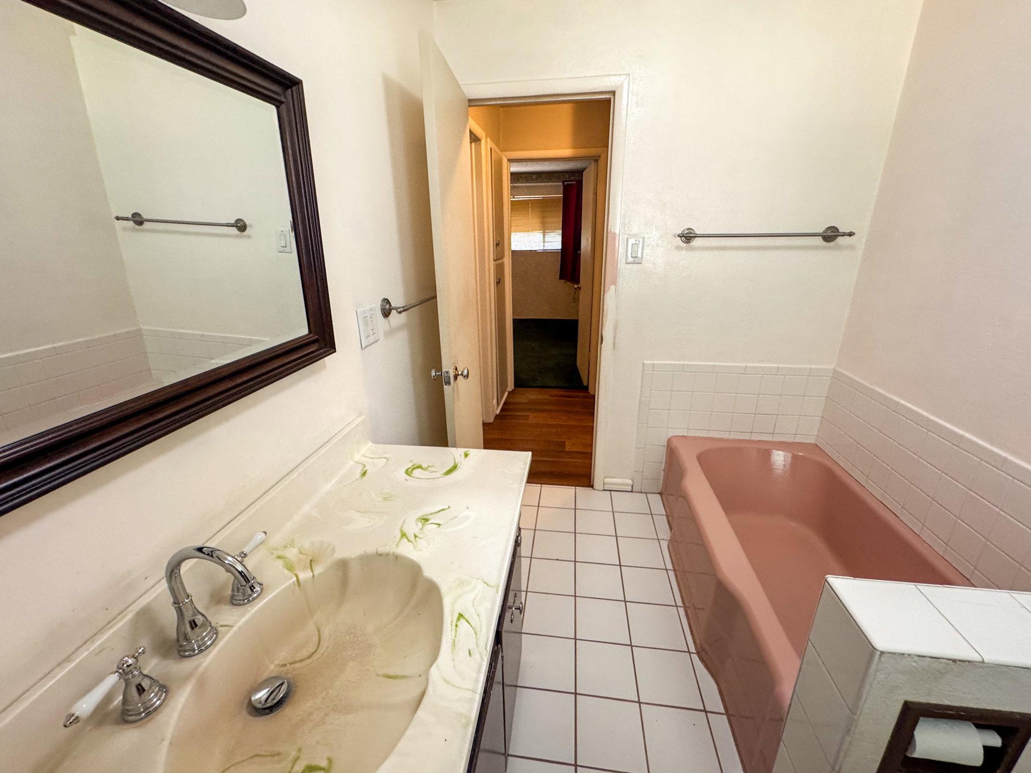 Bathroom featuring a vanity with an integrated shell-shaped sink, chrome faucet, and a framed mirror