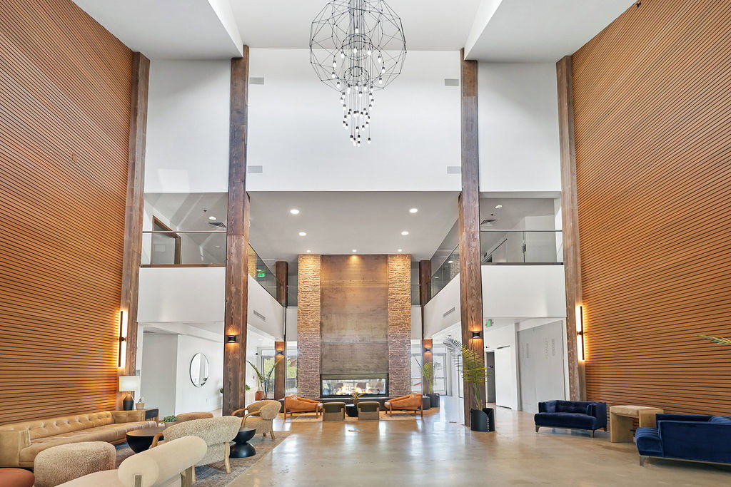 Two-story communal lobby with two-way fireplace, towering ceilings and wood-finished wall paneling