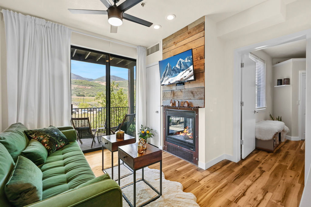 Livingroom featuring a gas fireplace, ceiling fan. Opens to a spacious balcony overlooking ski slopes