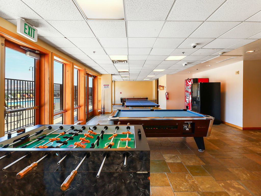 Recreational room featuring multiple game tables, including a foosball table and two billiard tables