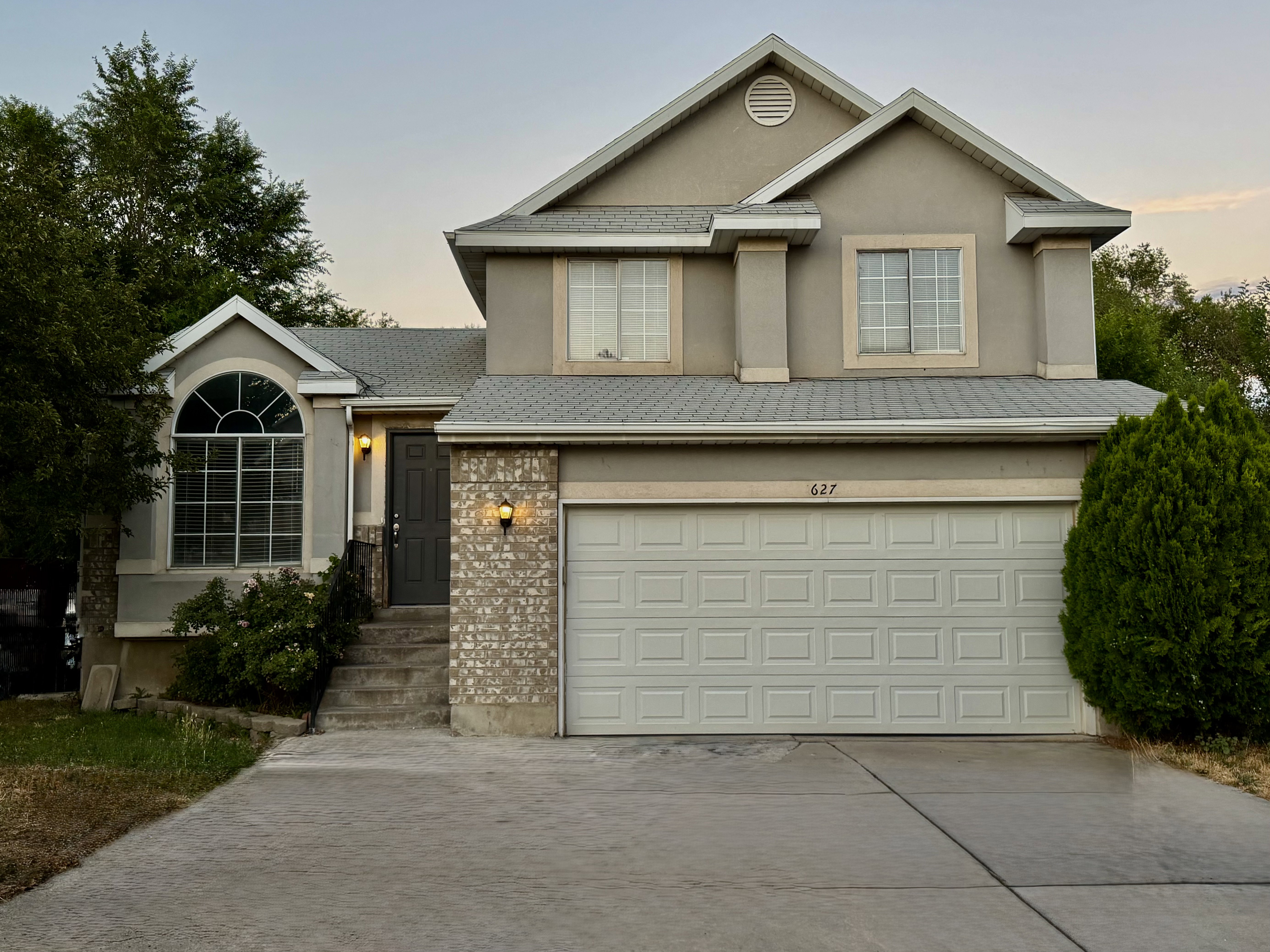 Two-story property featuring a front-facing attached garage and a concrete driveway