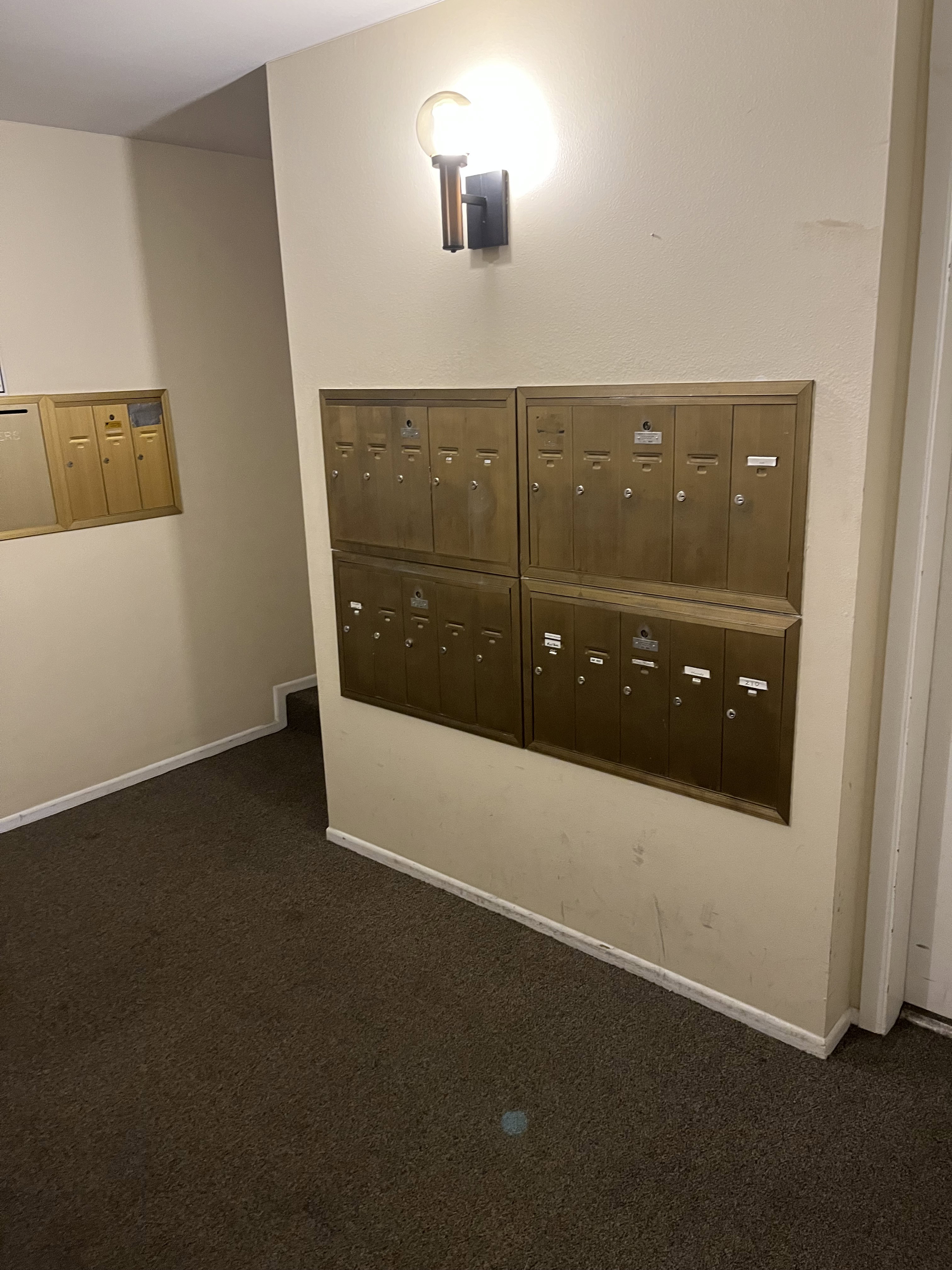 Wall-mounted mailboxes featuring a brass-tone finish