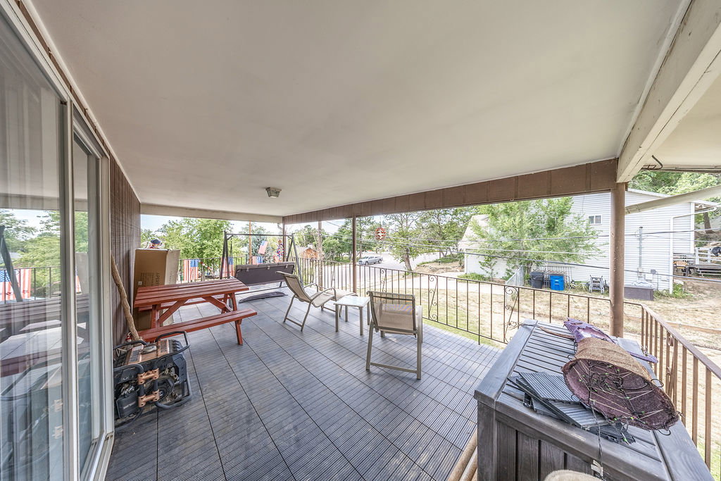 Covered porch featuring durable composite decking and a wrought-iron railing. Accessible from the master suite and the backyard.