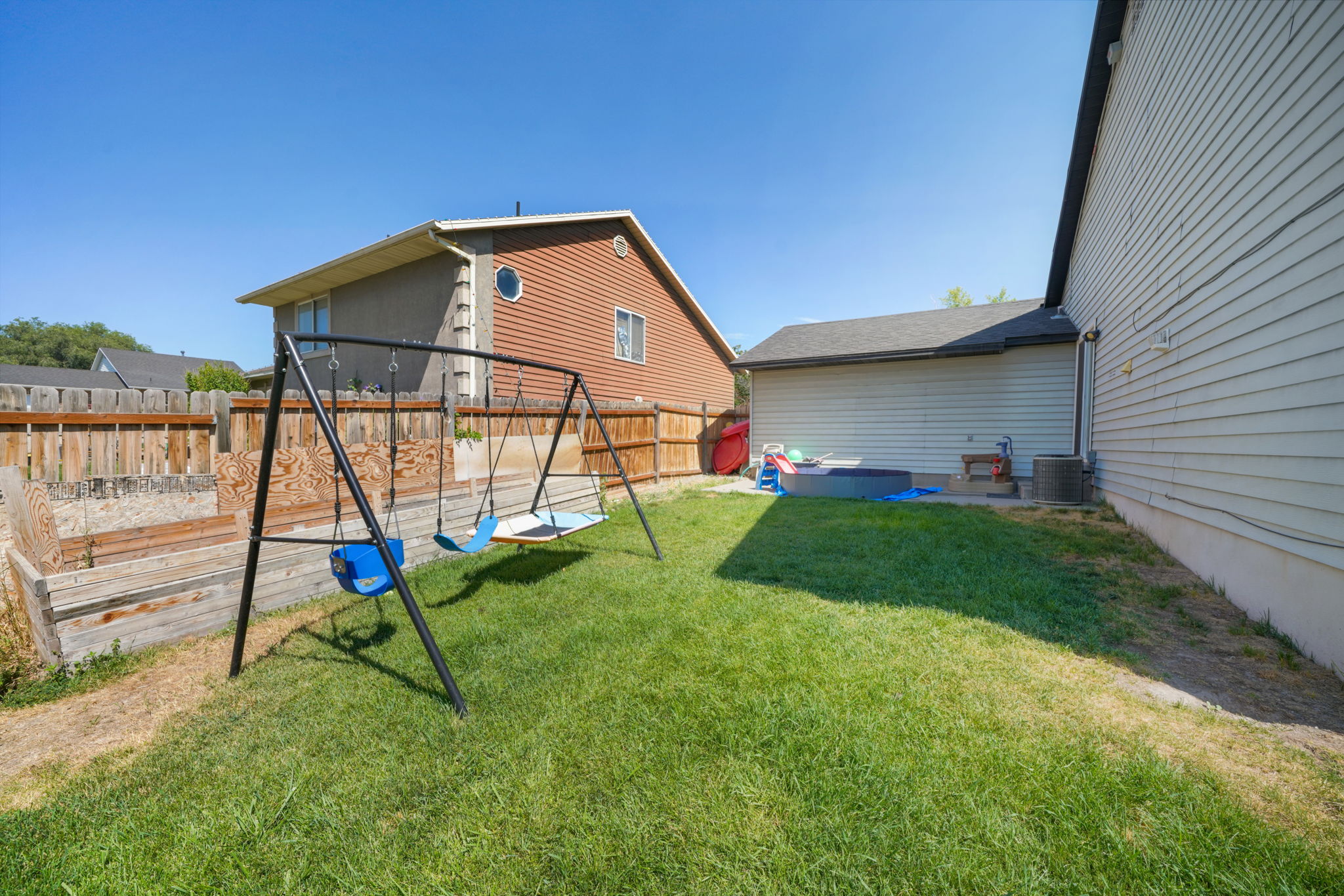 Expansive grassy yard area with a permanent wood fence