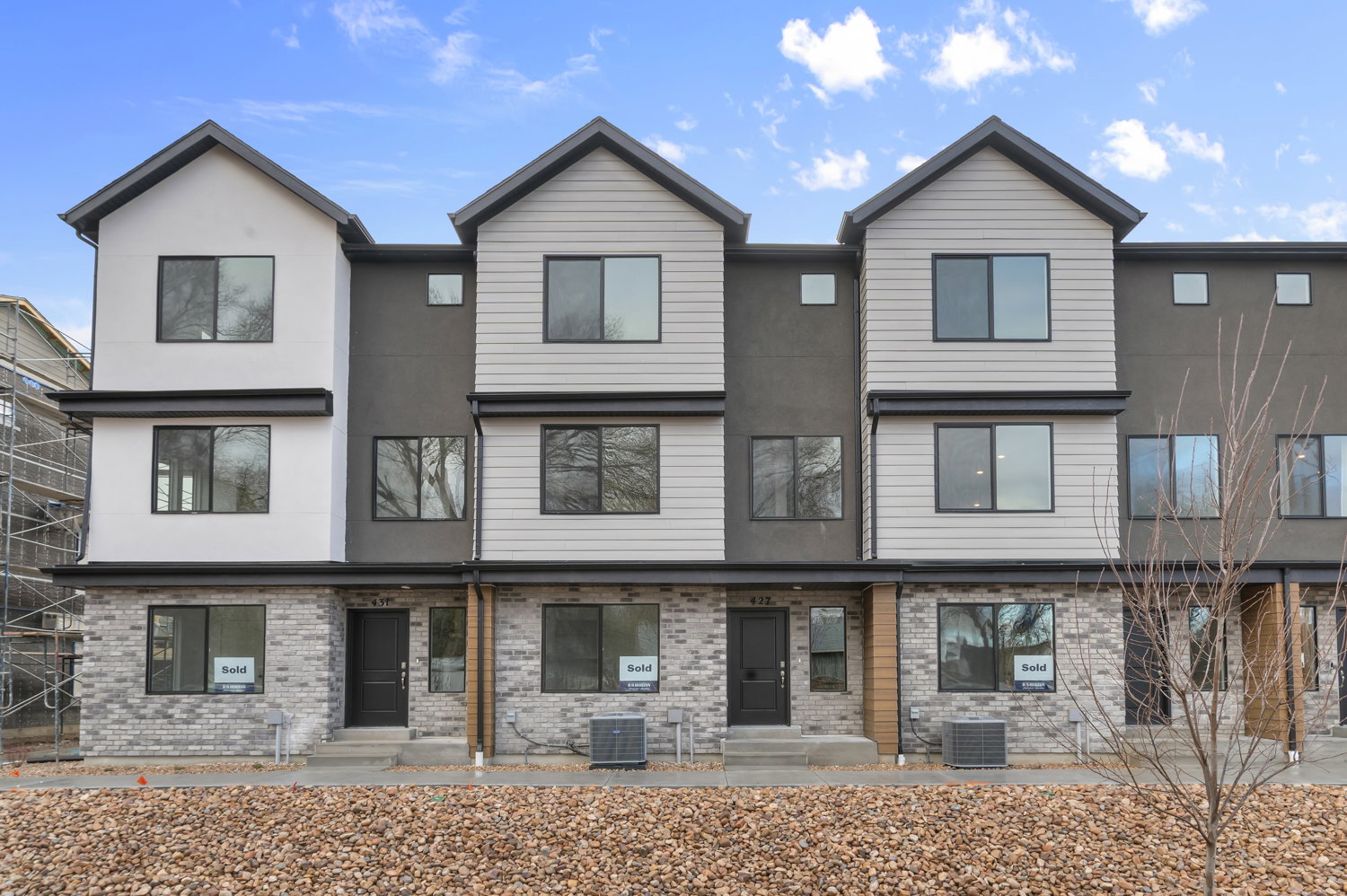 Contemporary townhome architecture featuring a multi-textured facade