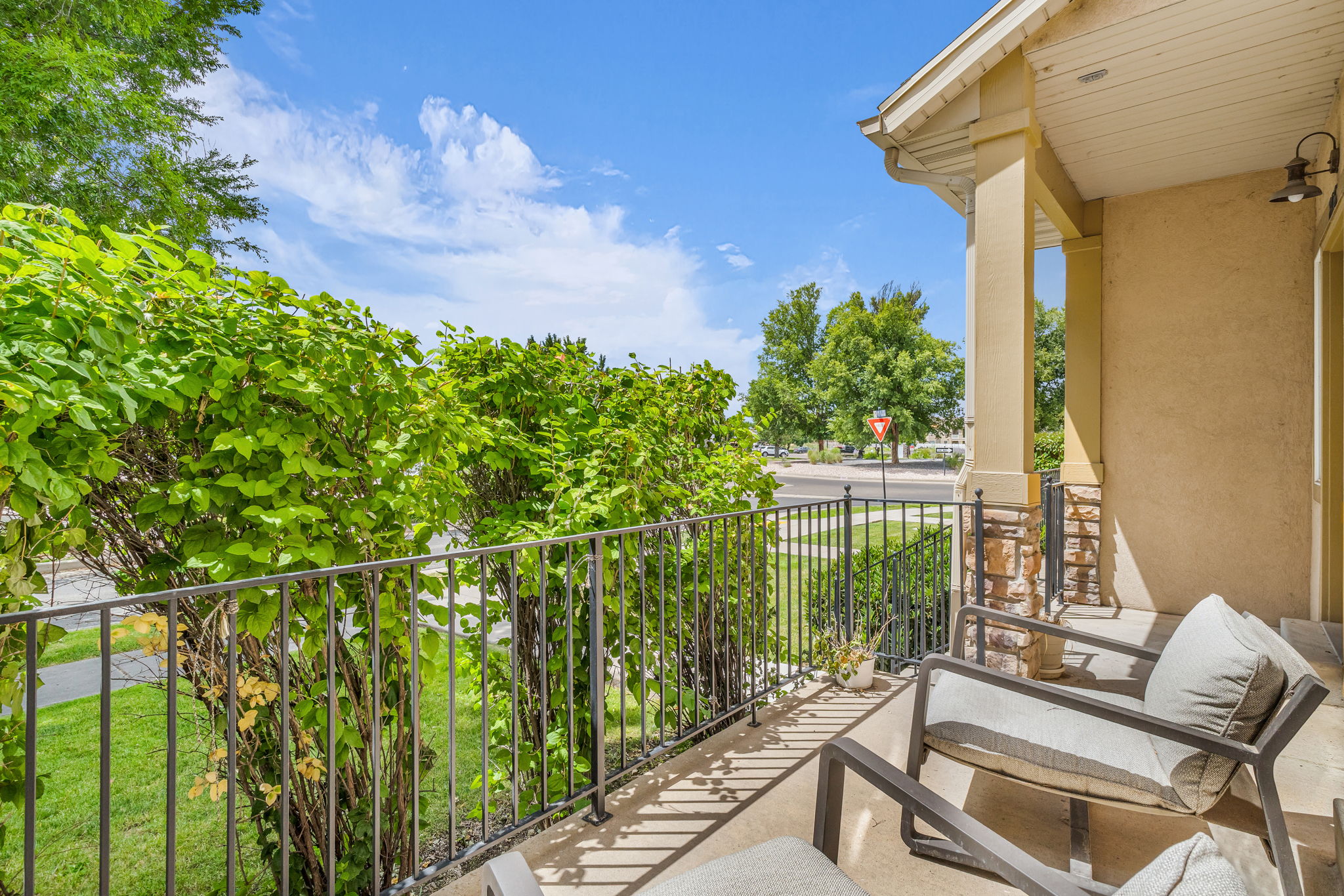 Covered porch featuring stucco siding and stone veneer accents