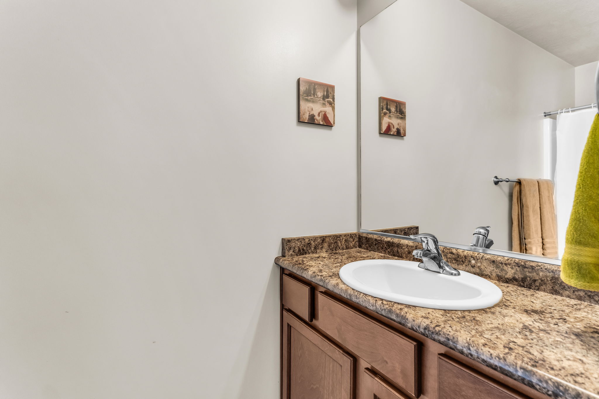 Bathroom vanity featuring an integrated oval sink, chrome faucet, and a speckled countertop